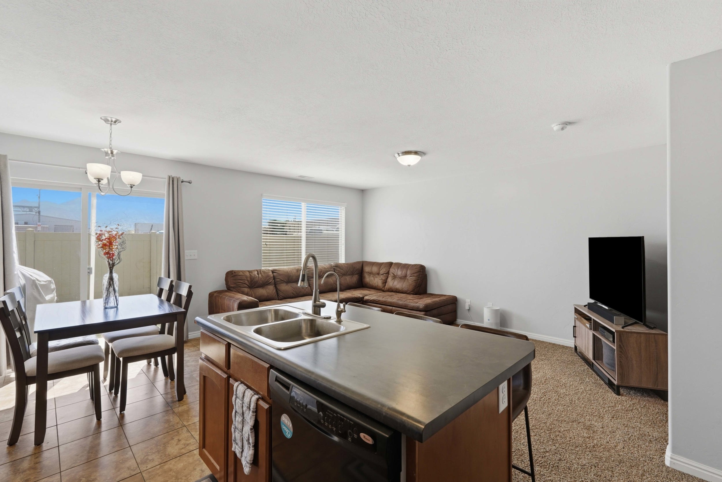 Kitchen island featuring a double-basin stainless steel sink and integrated dishwasher
