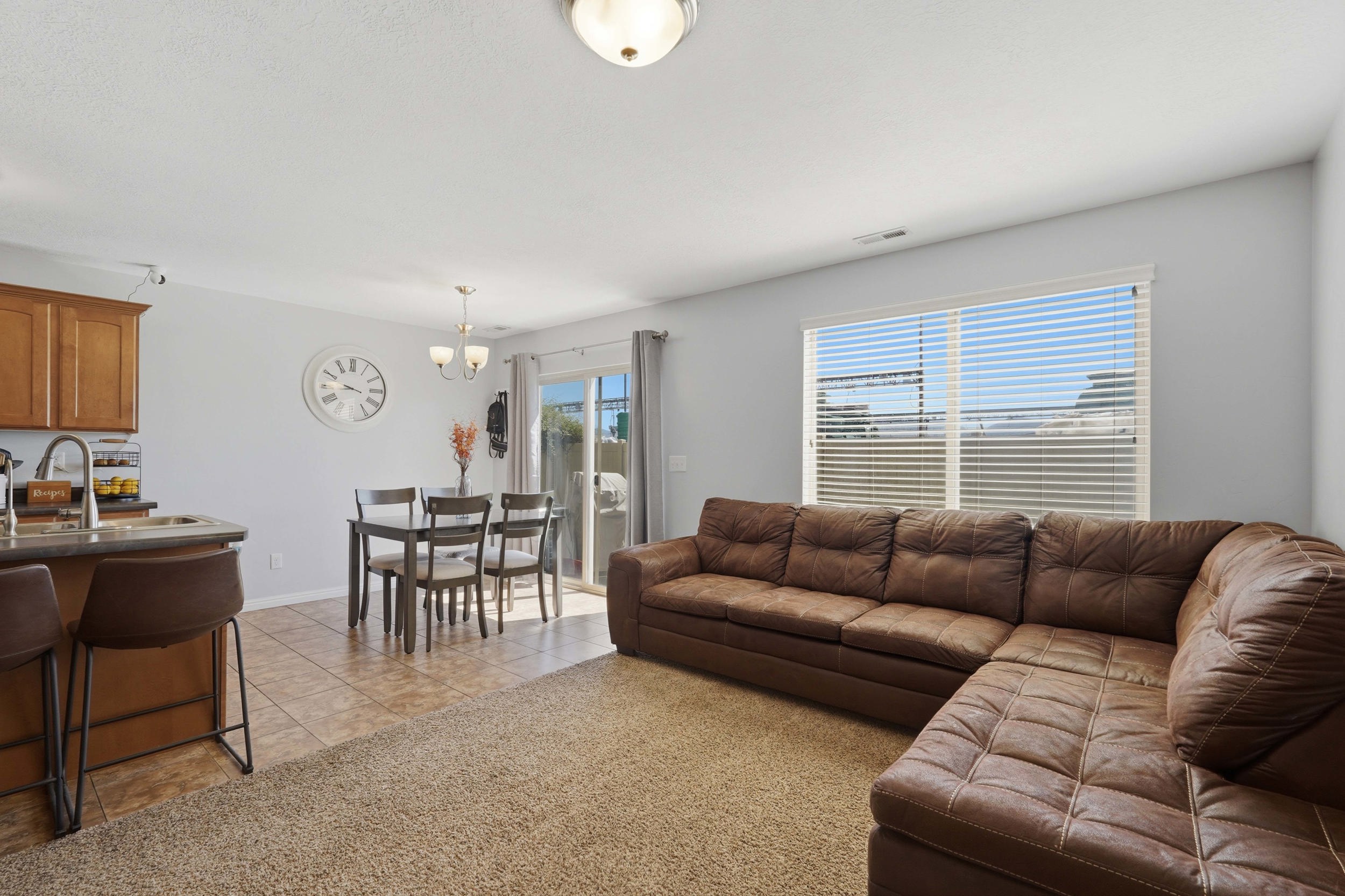 Open concept living space featuring a carpeted living area, dining area, and kitchen