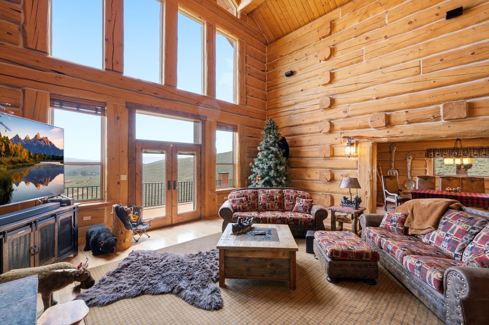 Expansive living area featuring soaring ceilings and exposed log construction