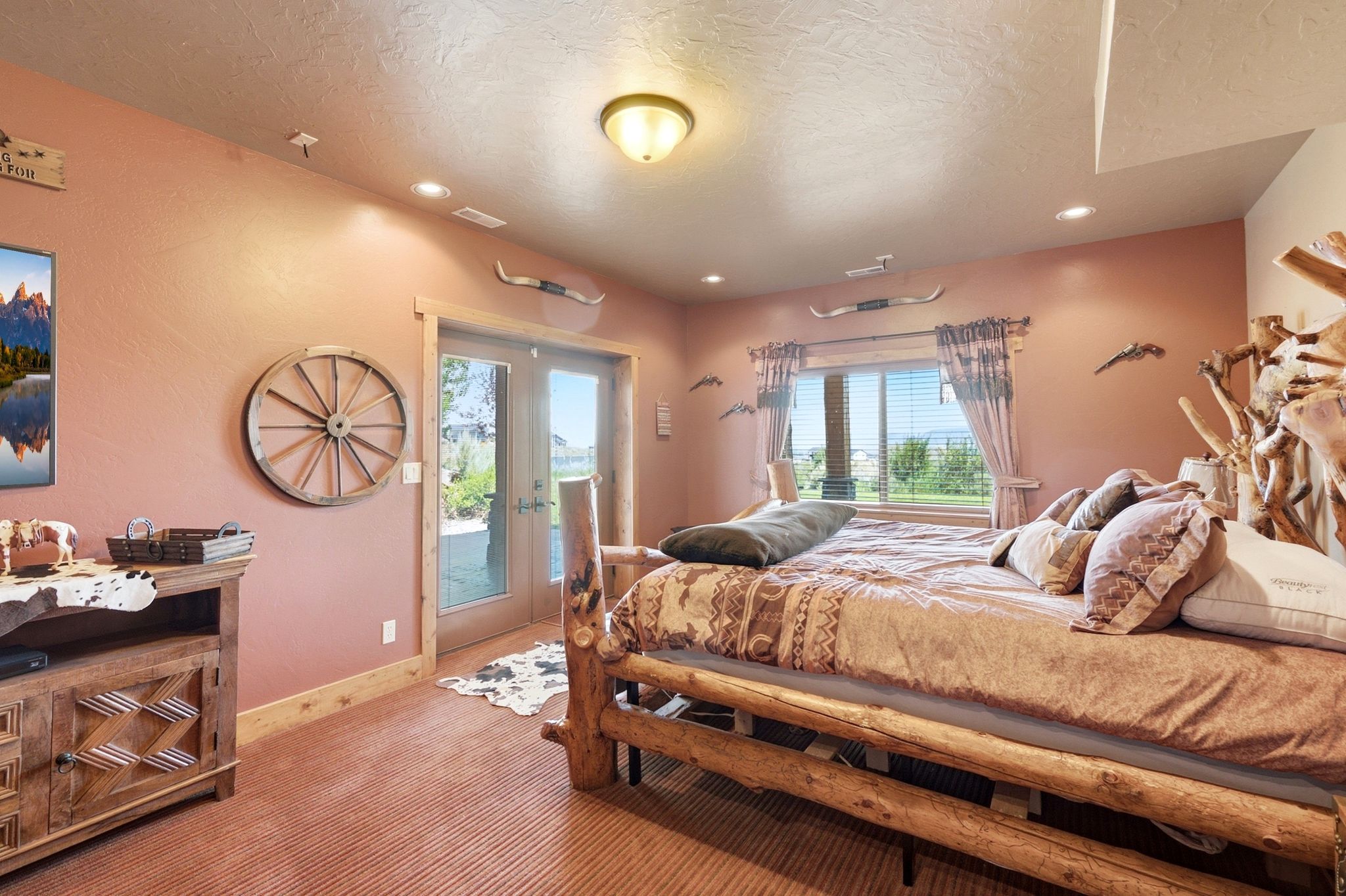 Bedroom featuring direct outdoor access via French doors, a large window, recessed lighting, and textured wall finish