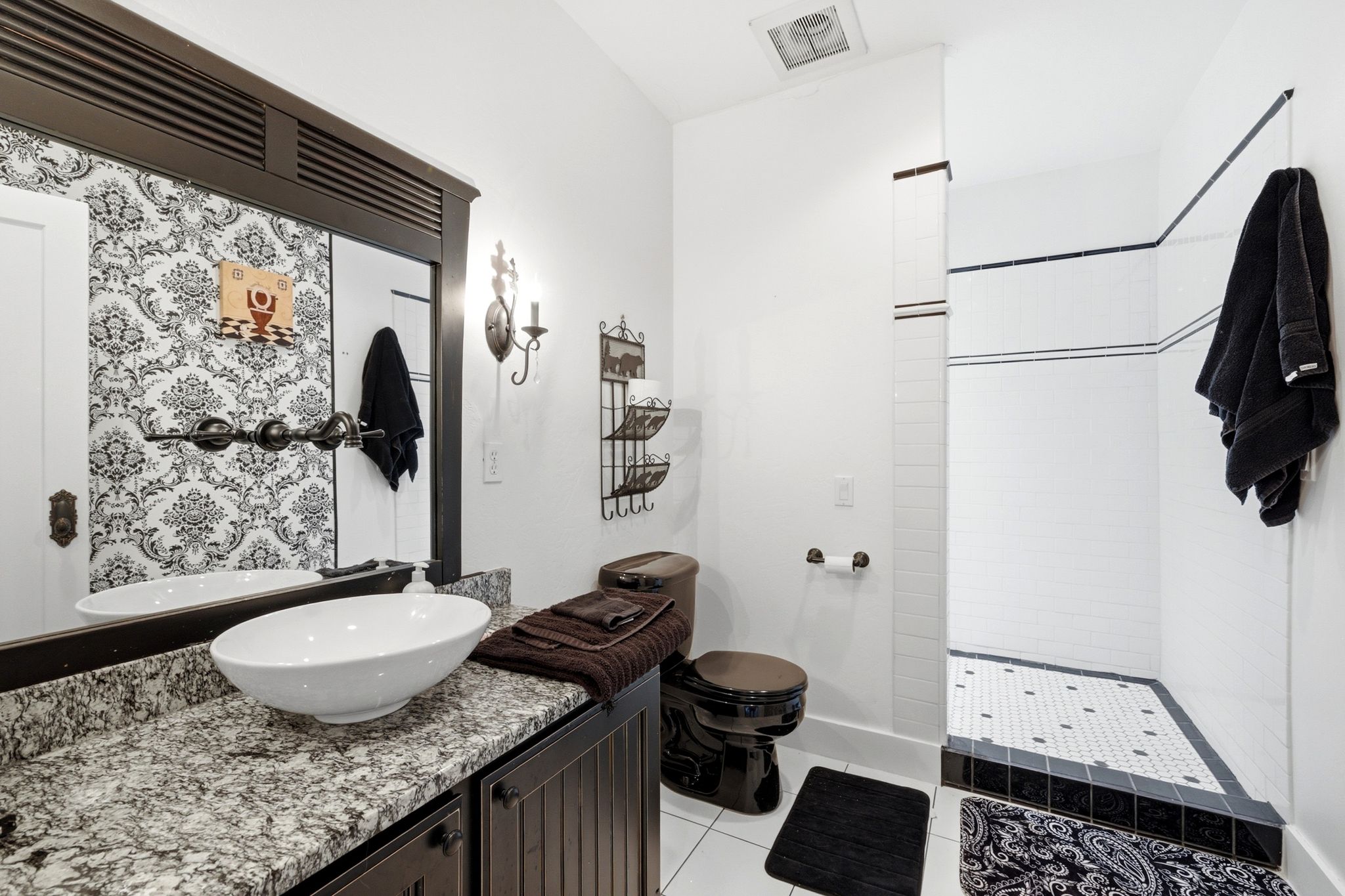 Bathroom featuring a dark wood-finish vanity with a granite countertop and vessel sink