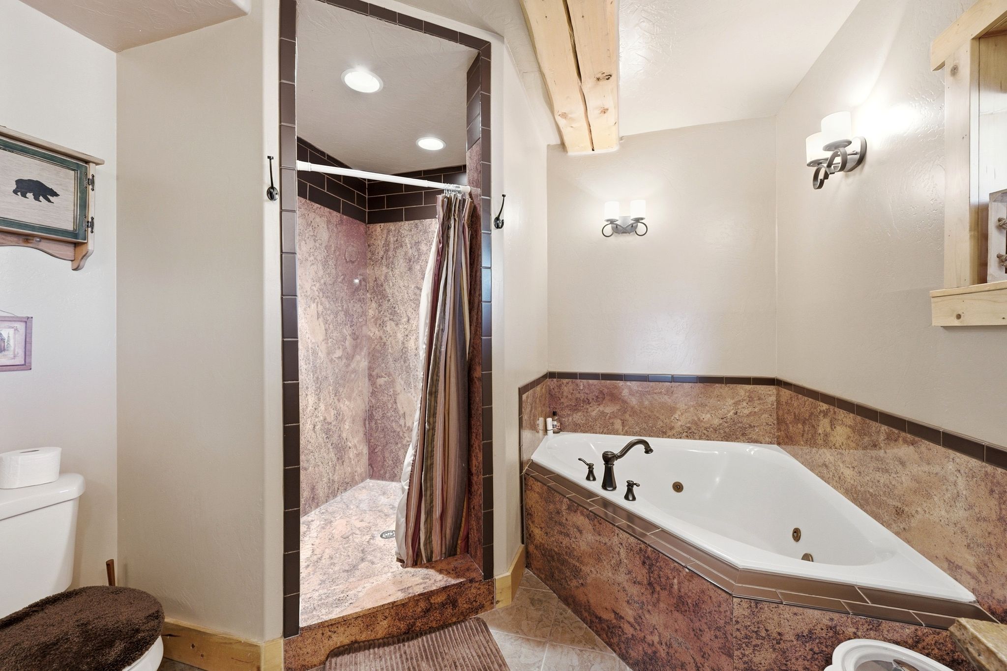 Corner jetted tub with tile surround, walk-in shower with tiled walls and recessed lighting, and wall-mounted sconce lighting