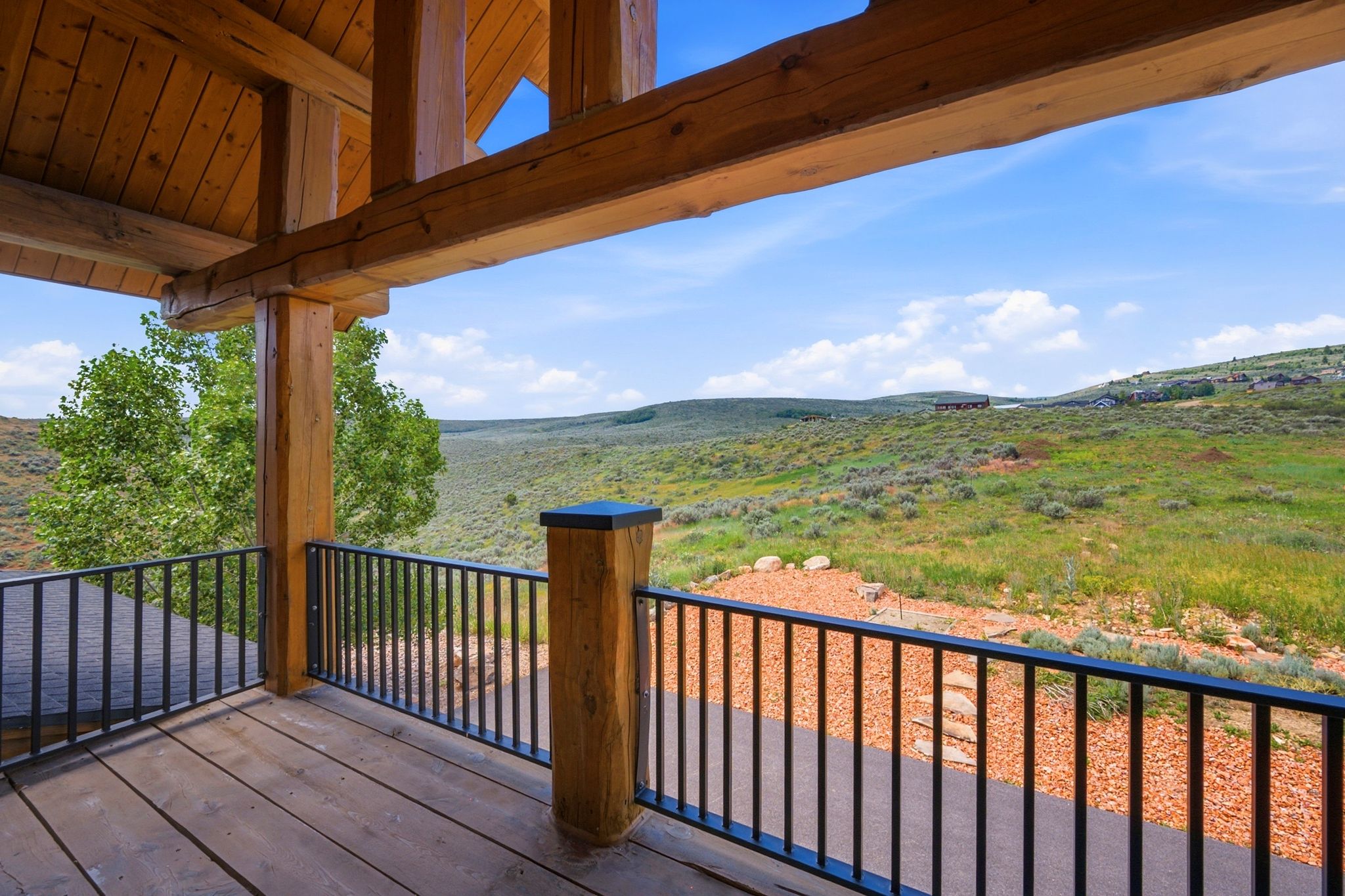 Expansive outdoor deck featuring wood-finish flooring and a black metal railing system