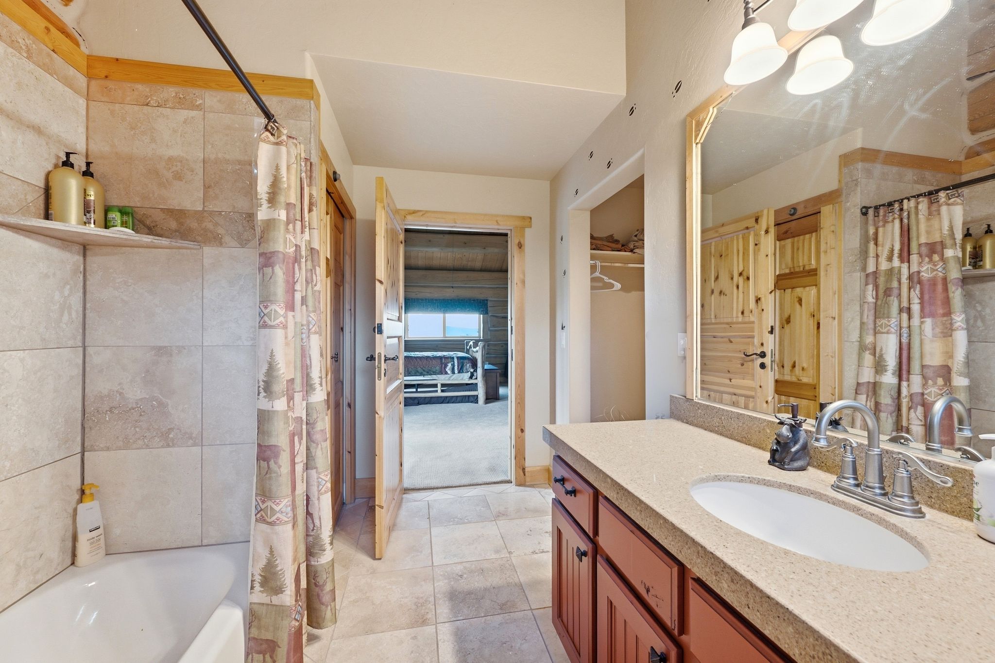 Bathroom featuring a vanity with a light-colored countertop and integrated sink, wood-finish cabinetry, and a framed mirror