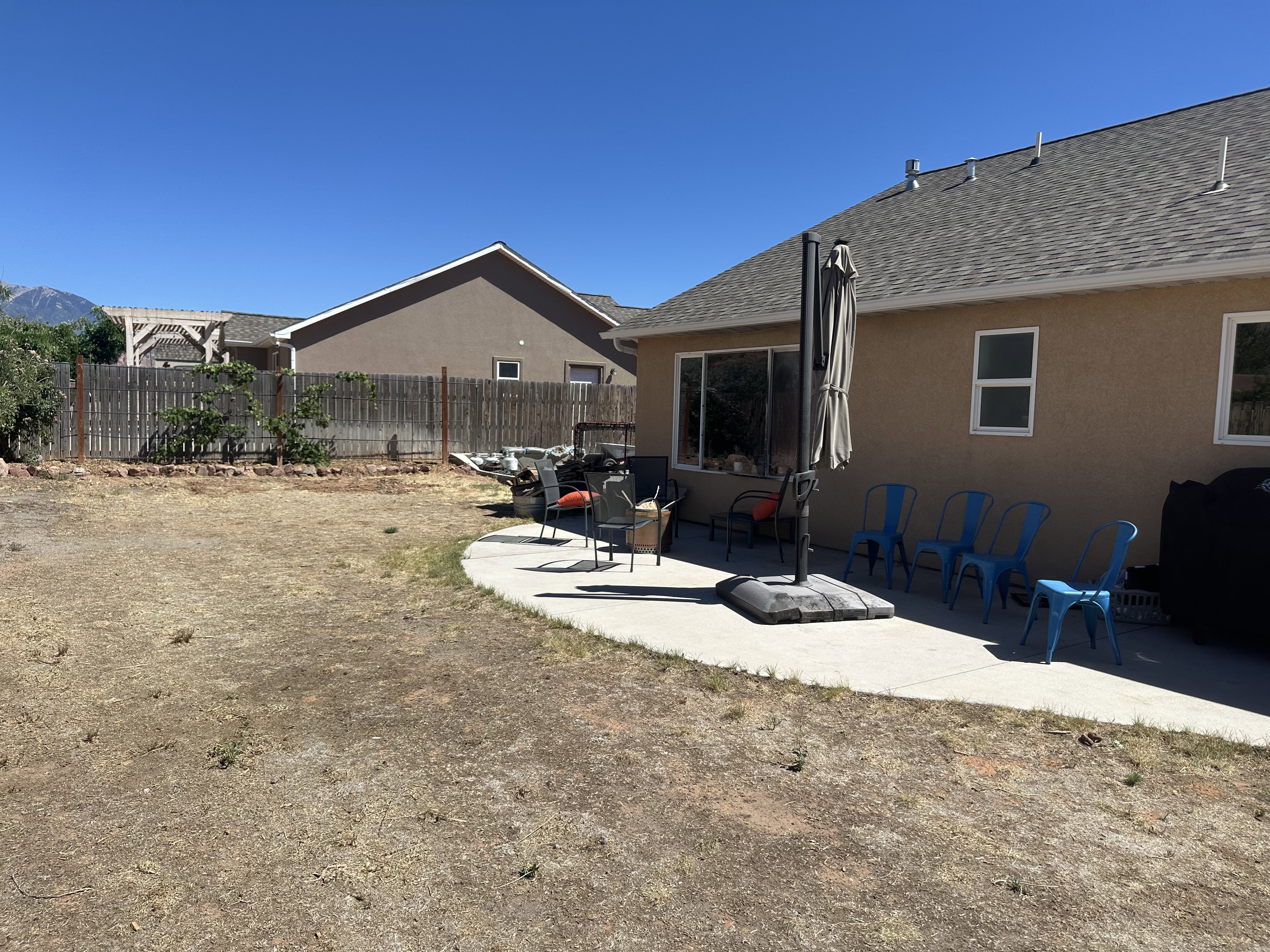 Rear exterior featuring a concrete patio, stucco siding, and a shingle roof