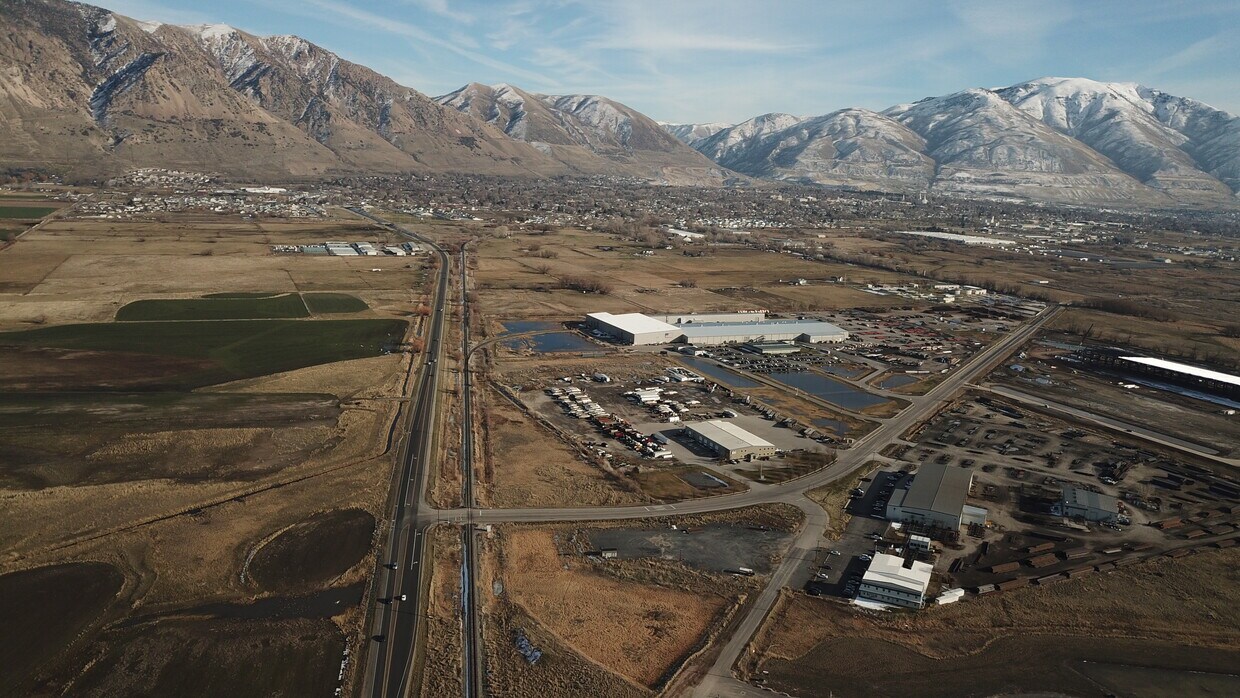 Expansive aerial perspective showcasing a rural landscape with distant snow-capped mountains