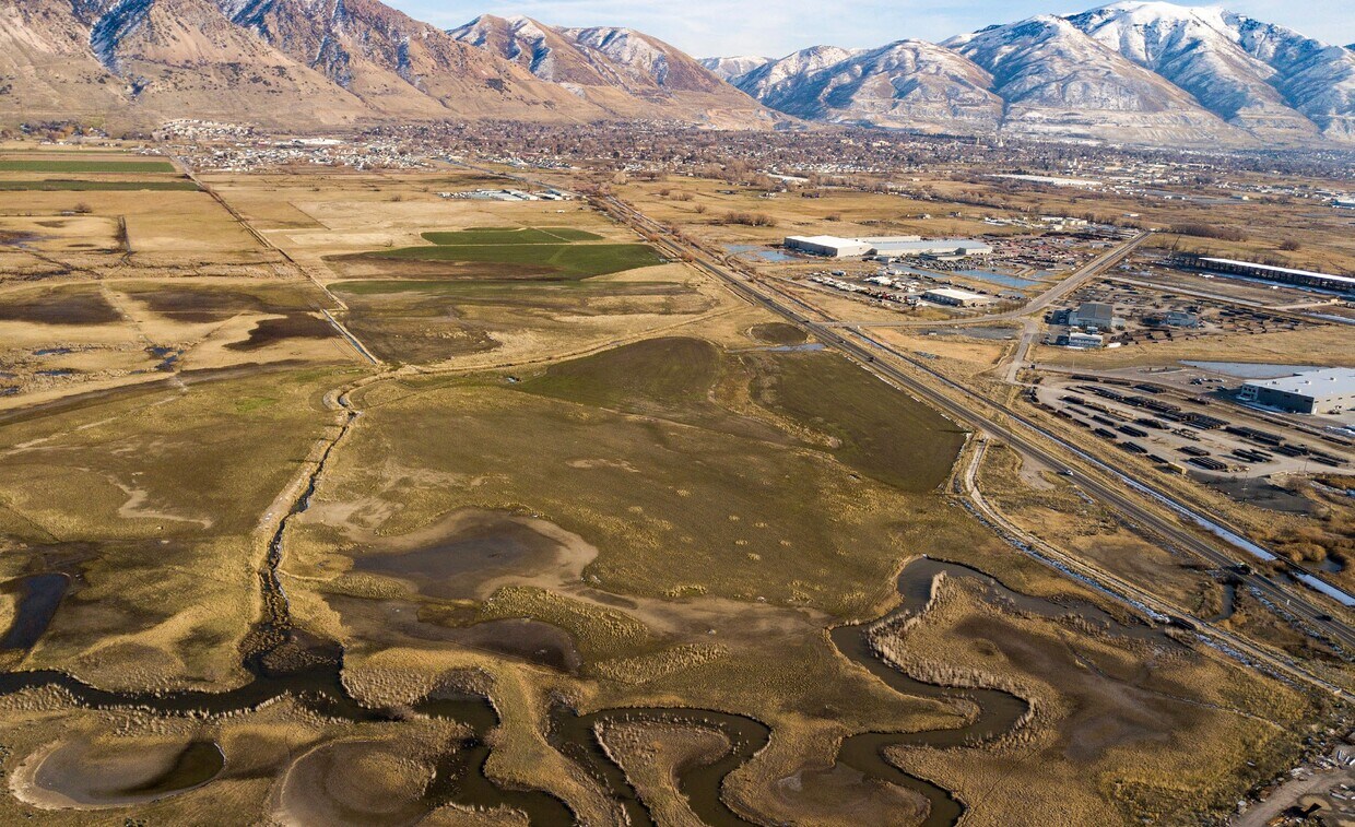 Expansive undeveloped land featuring natural waterways and scattered vegetation
