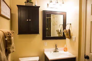 Bathroom vanity featuring a single basin sink, chrome faucet, and a dark wood-finish cabinet