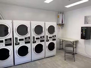 Dedicated laundry area featuring multiple commercial-grade washer and dryer units