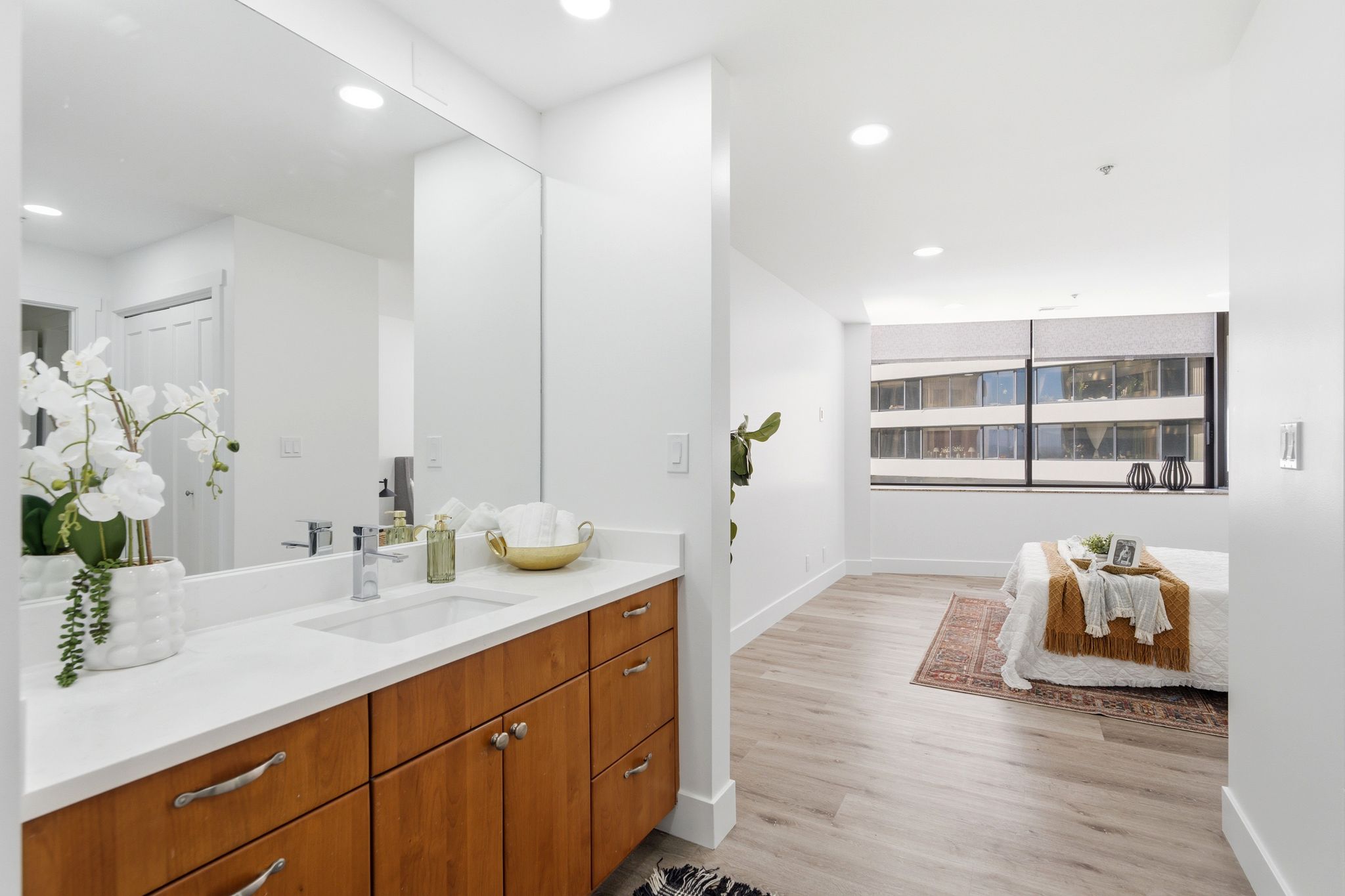 Master Bathroom vanity featuring a light wood-finish cabinet with silver hardware, an integrated white rectangular sink, and a white countertop