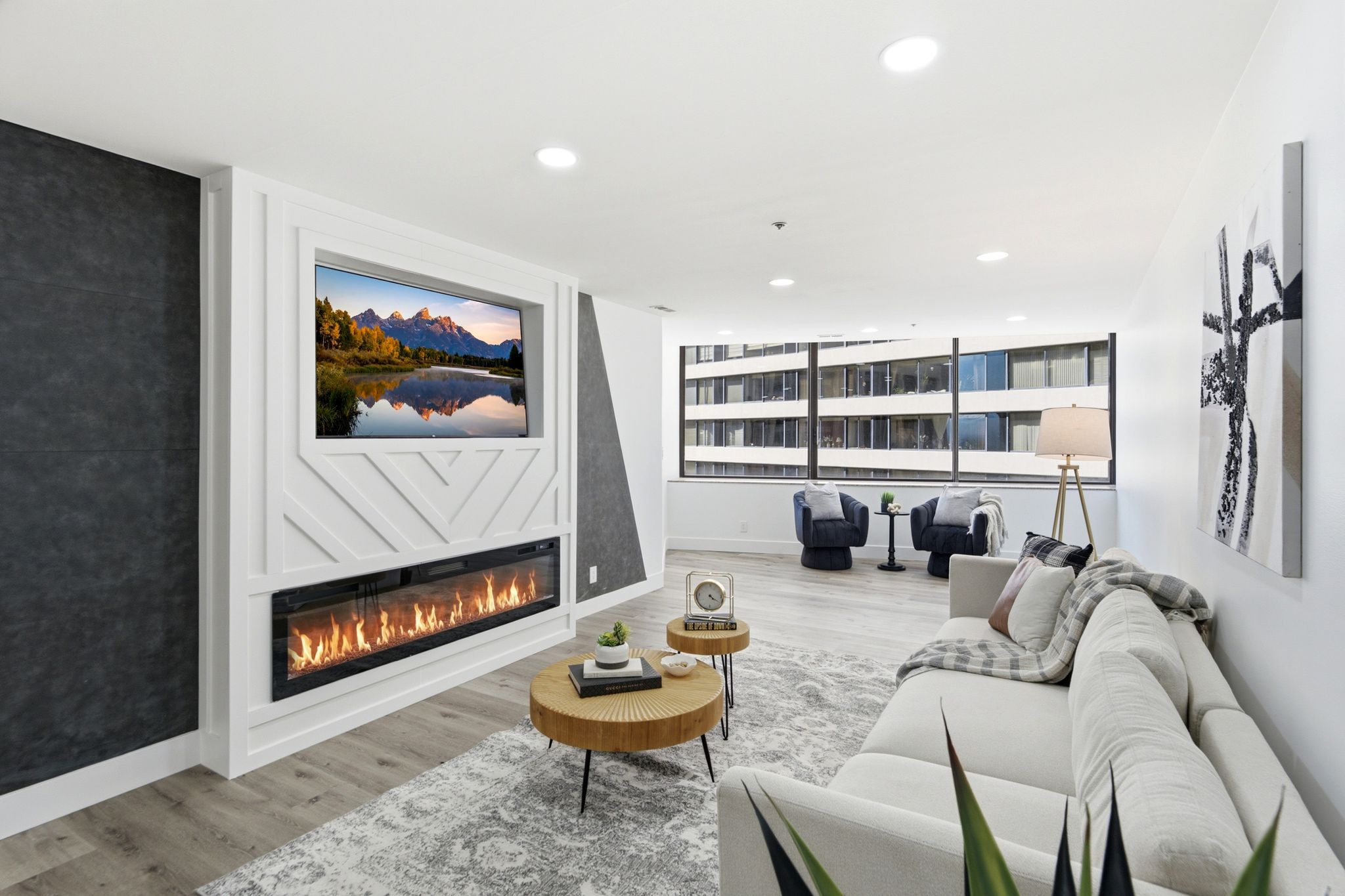 Living area featuring a white accent wall with geometric paneling and a built-in linear fireplace