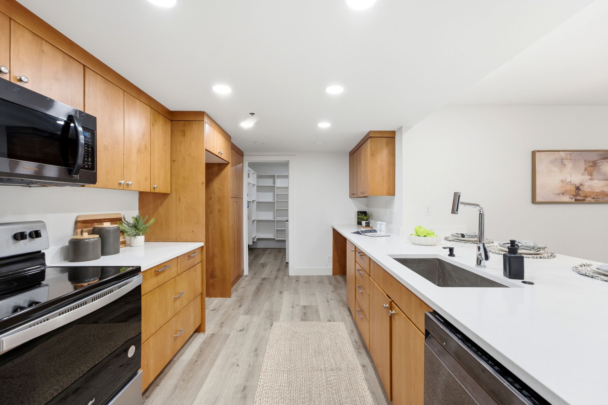 Modern kitchen featuring wood cabinetry, white countertops, built-in appliances, recessed lighting, and wood-finish flooring