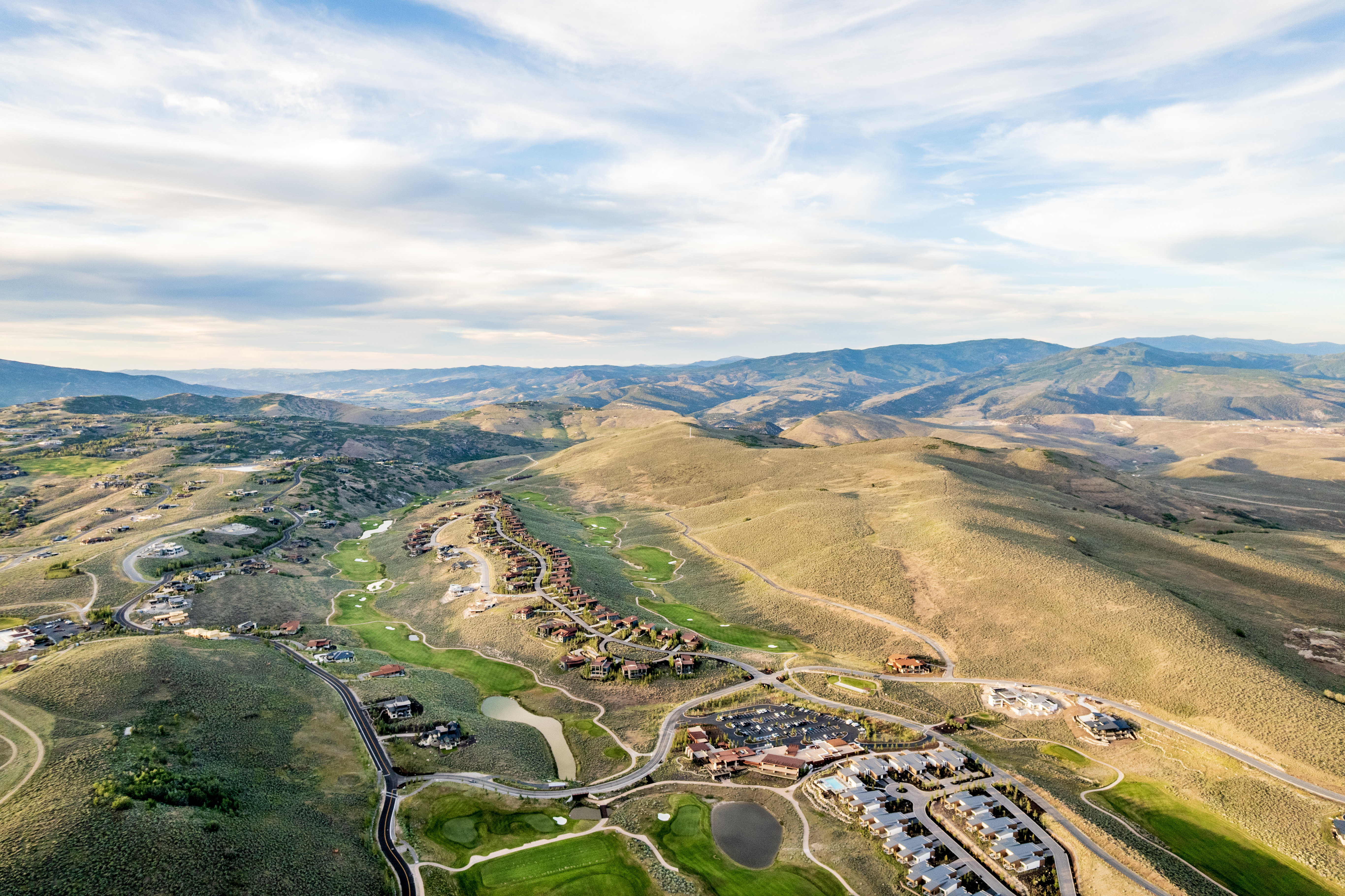 Expansive mountain landscape featuring residential developments, golf courses, and roadways