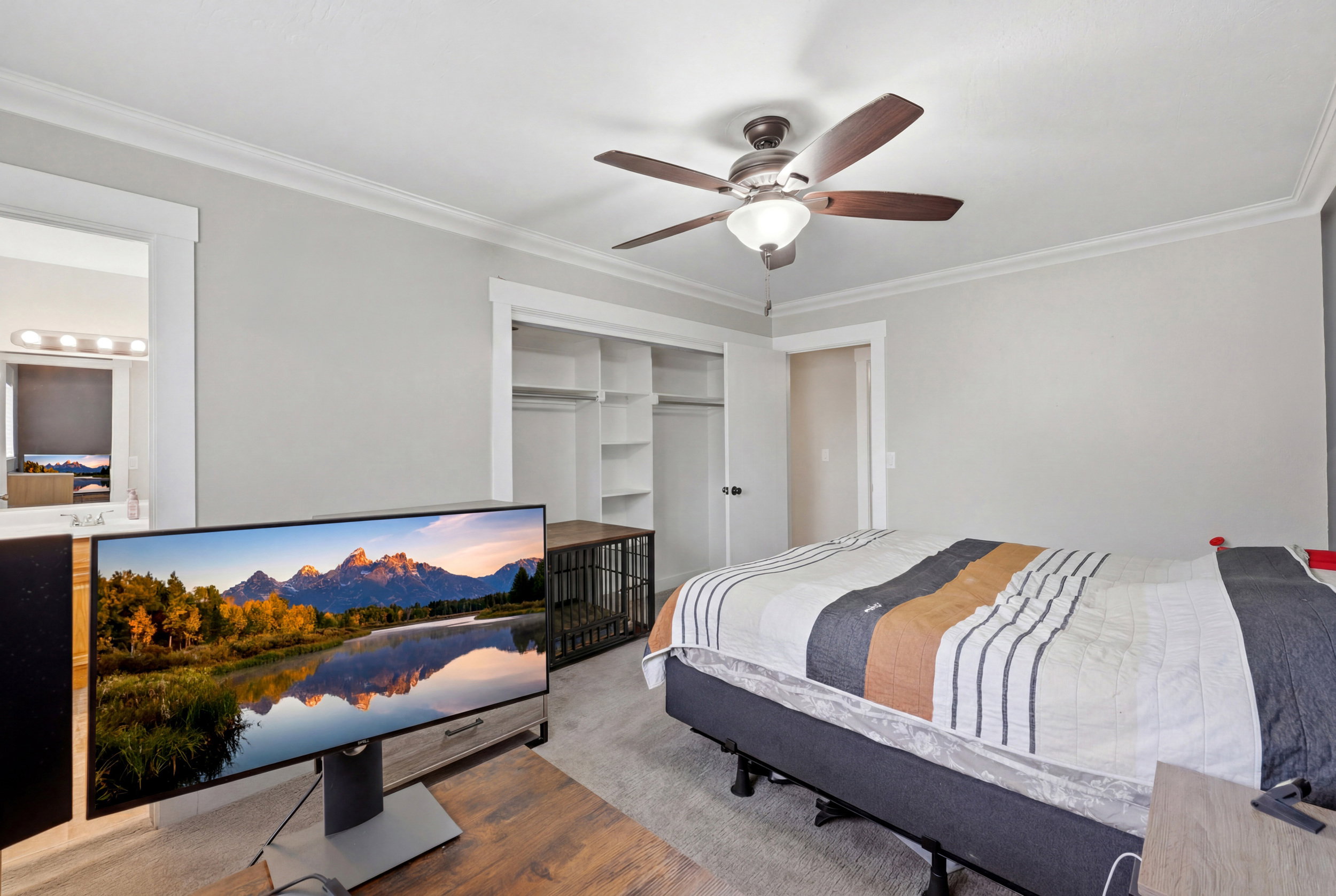 Bedroom featuring light gray walls, white crown molding, and a brown ceiling fan with an integrated light fixture