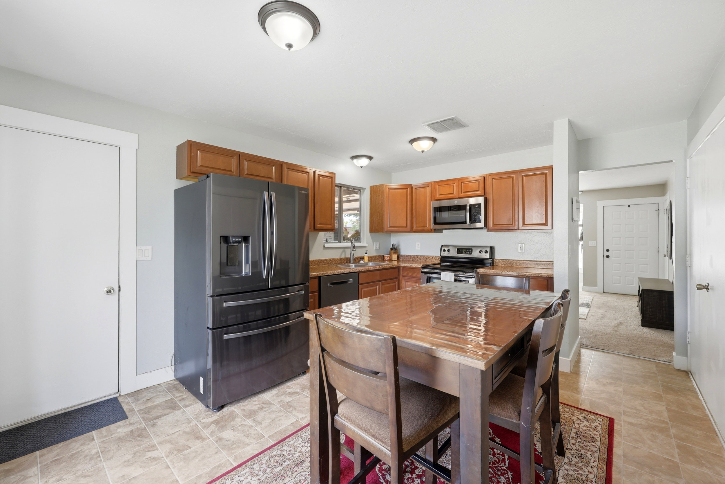 Kitchen featuring wood-finish cabinetry, stainless steel appliances, and a tiled backsplash
