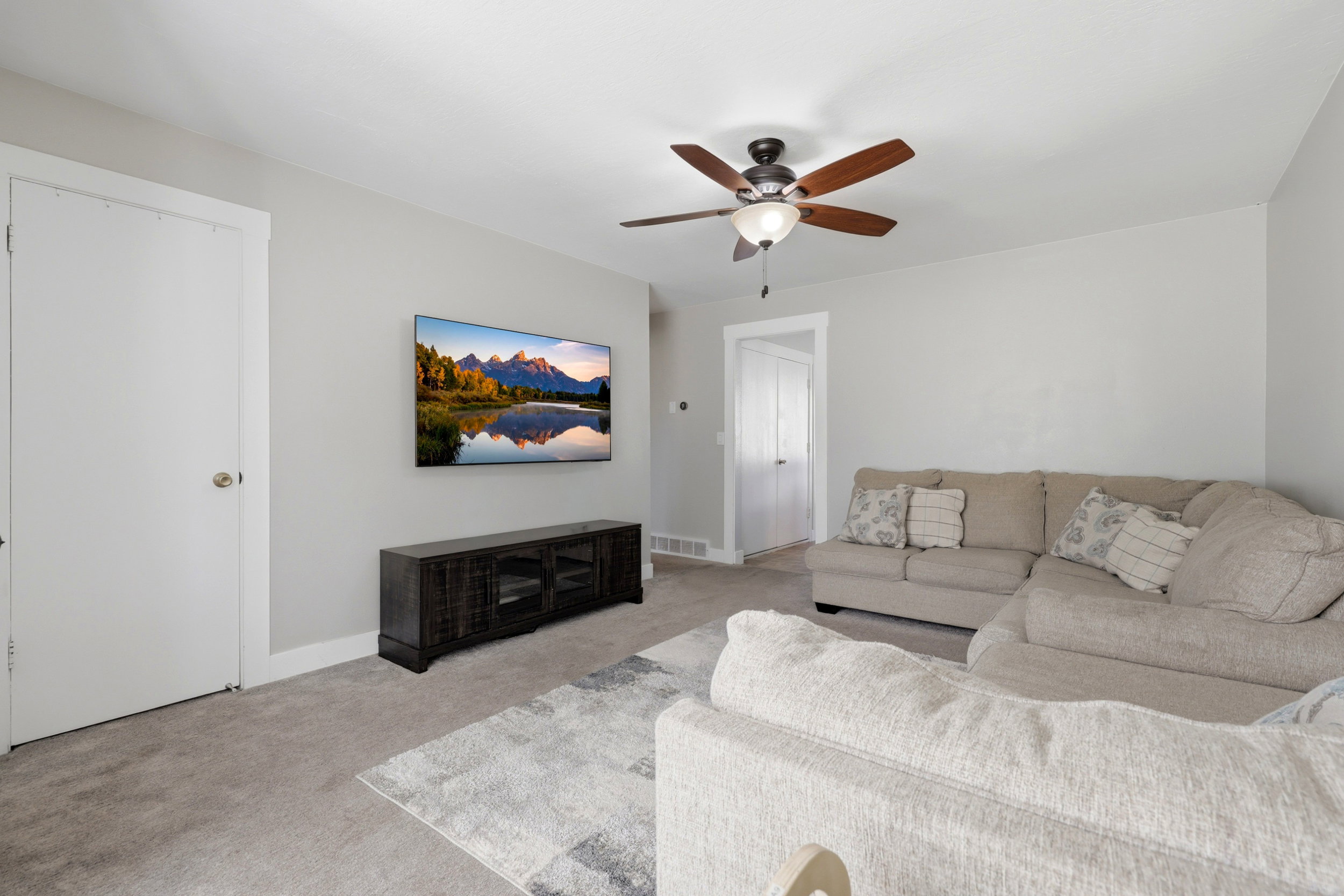Carpeted living space with light gray wall paint and white trim