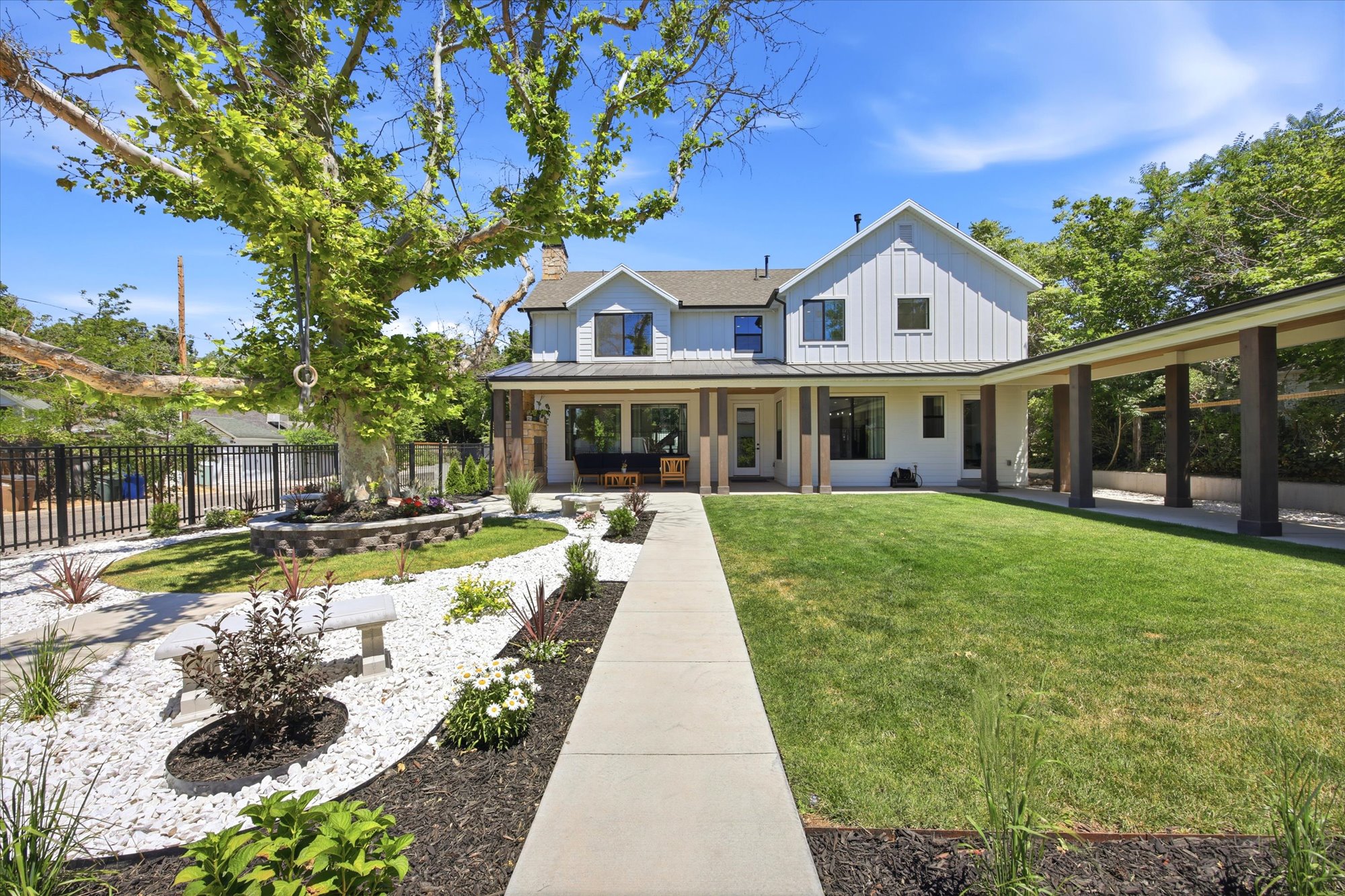 Contemporary home with board and batten siding, a covered porch, and an attached covered walkway