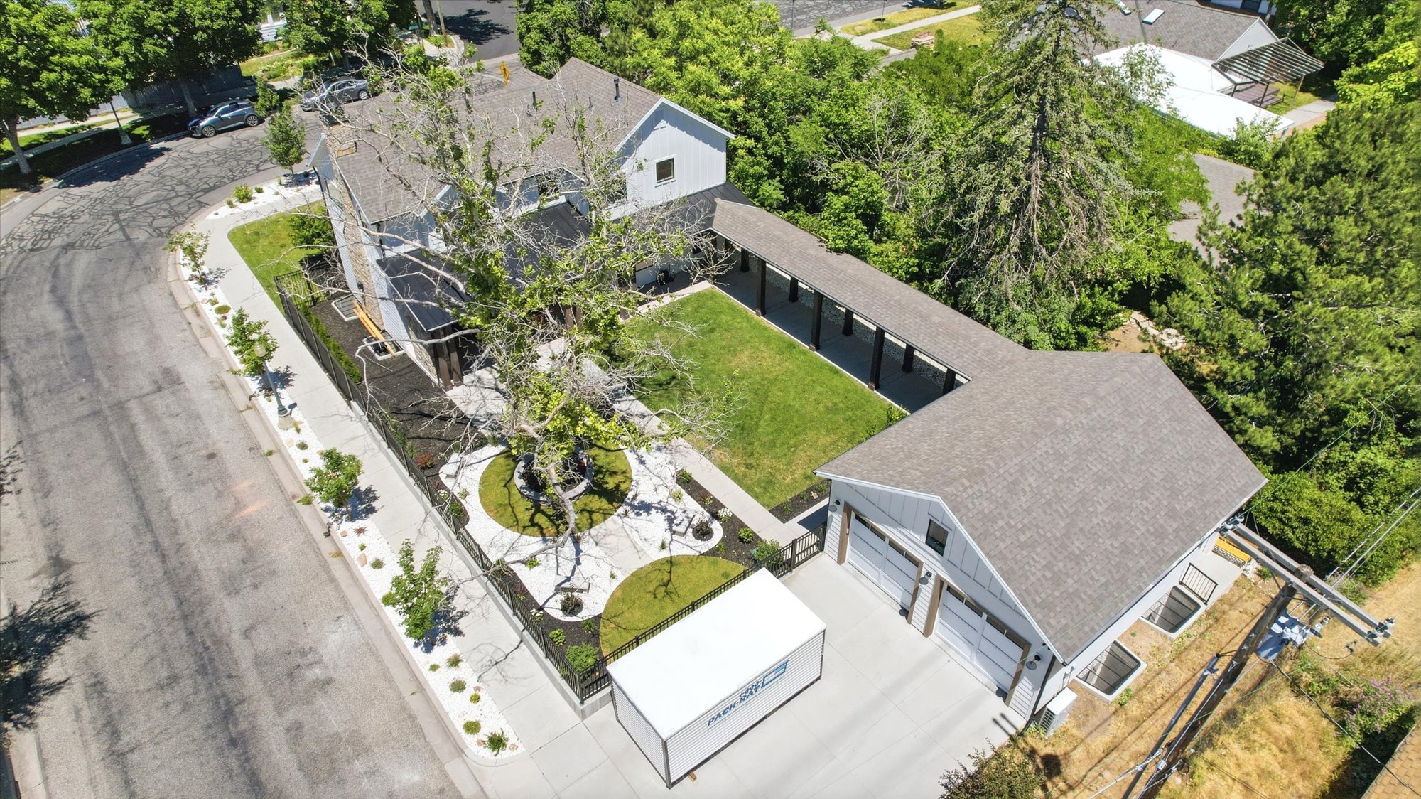 Aerial property overview featuring a two-story residence with a detached three-car garage