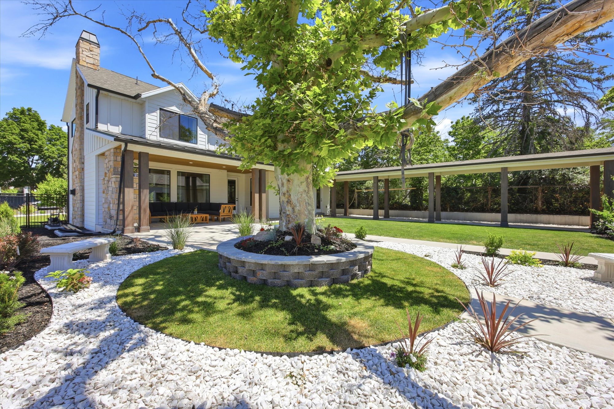 Landscaped exterior featuring white siding and stone accents