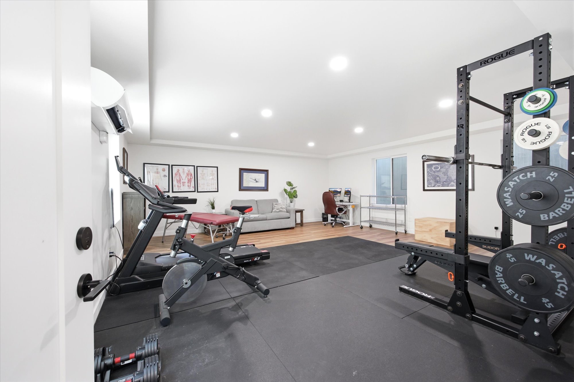 Basement home gym/flex space featuring dedicated fitness flooring, recessed lighting, wood-finish flooring, and a large window