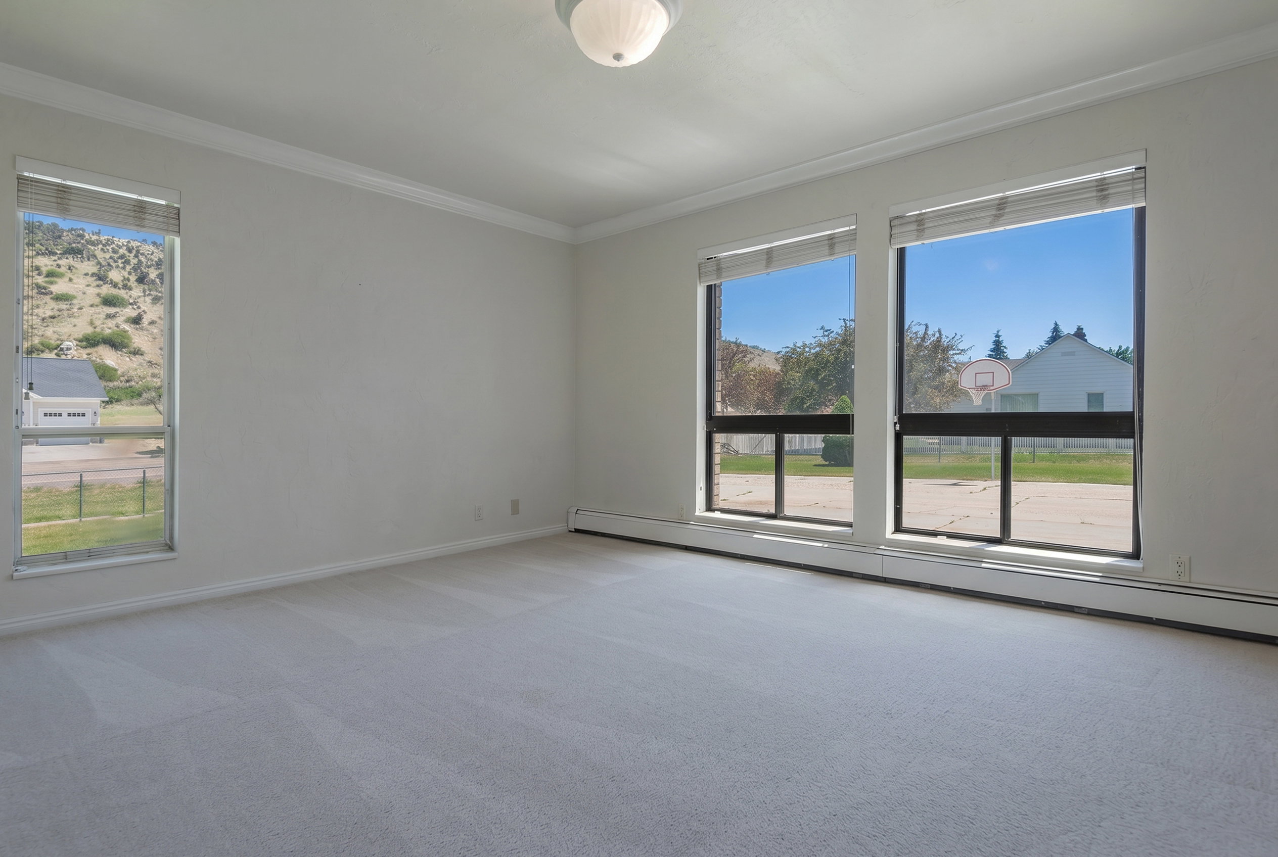 Spacious room featuring light gray carpeting and white walls