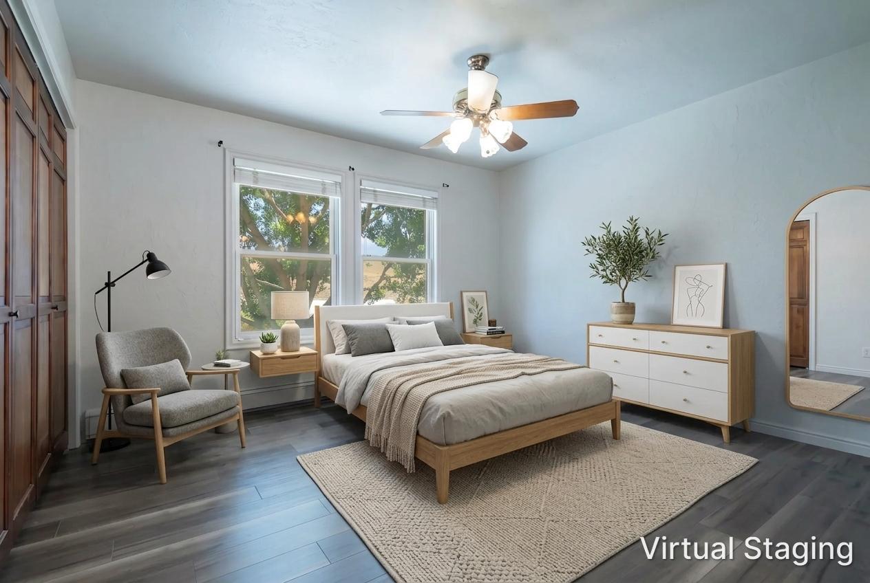 Spacious room featuring wood-finish flooring, light blue wall paint, and a ceiling fan with light fixture