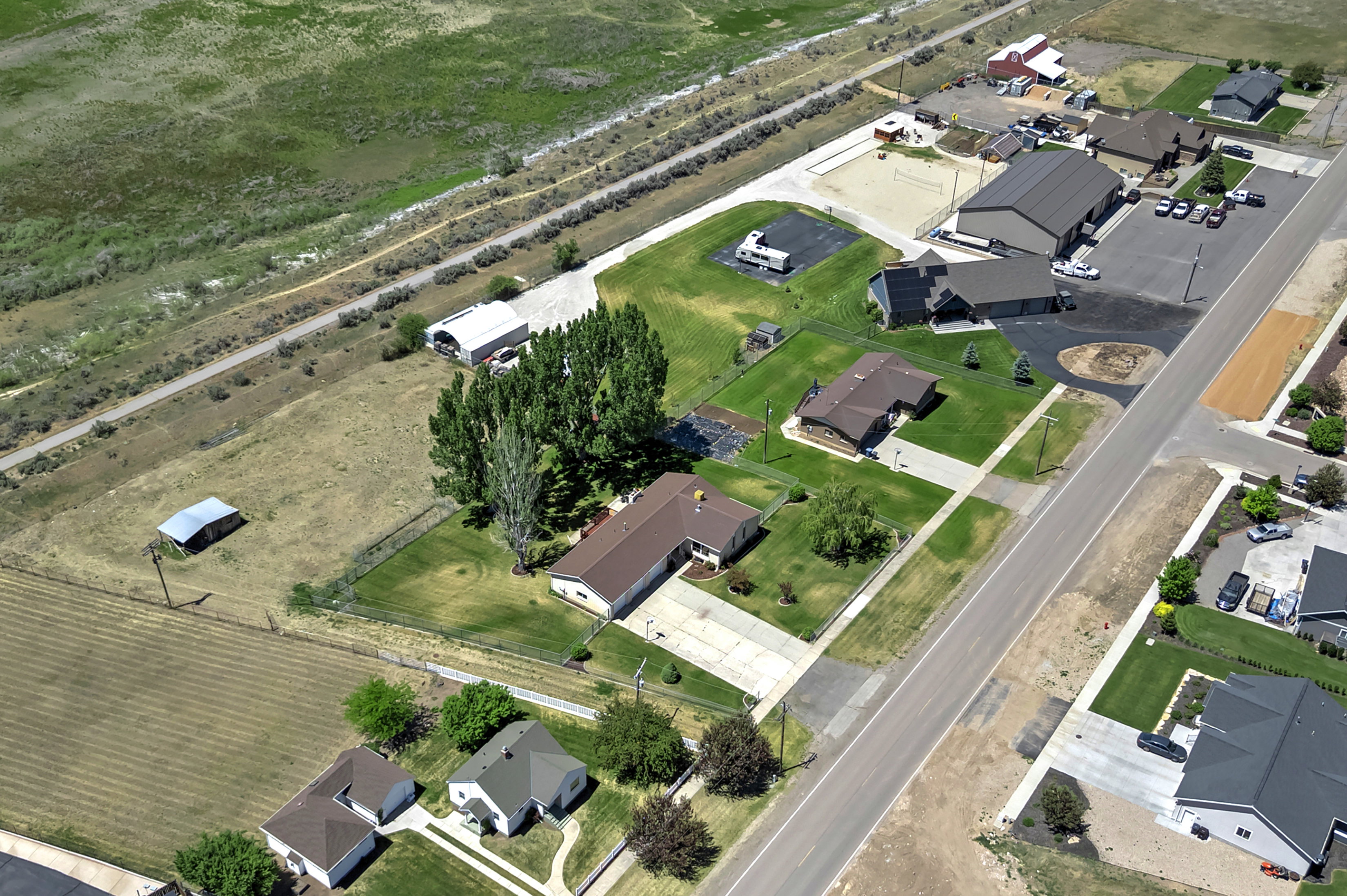 Aerial perspective showcasing multiple properties and surrounding topography