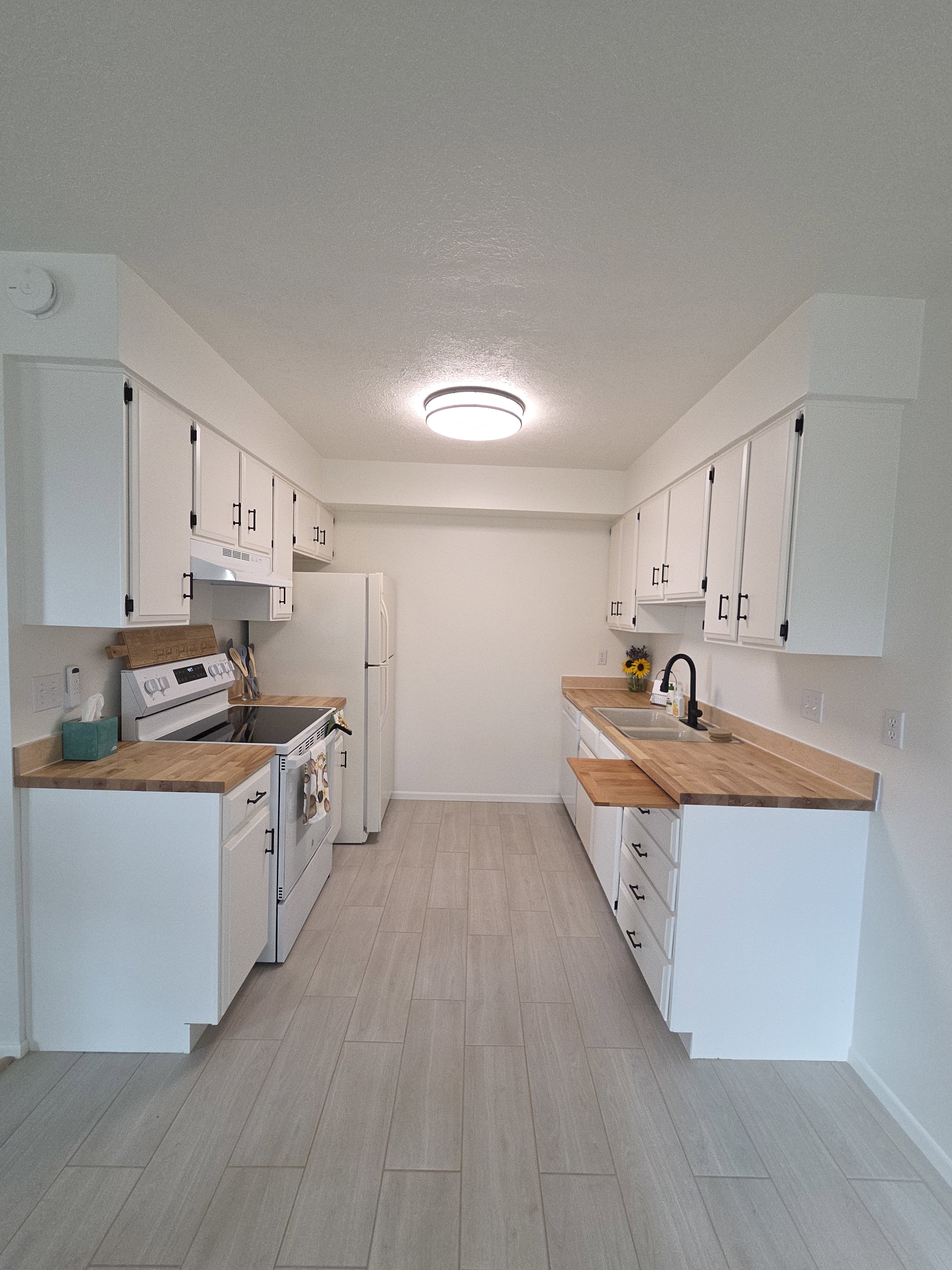 Updated kitchen with new range, range hood, dishwasher, butcher block countertops, faucet and tile flooring.