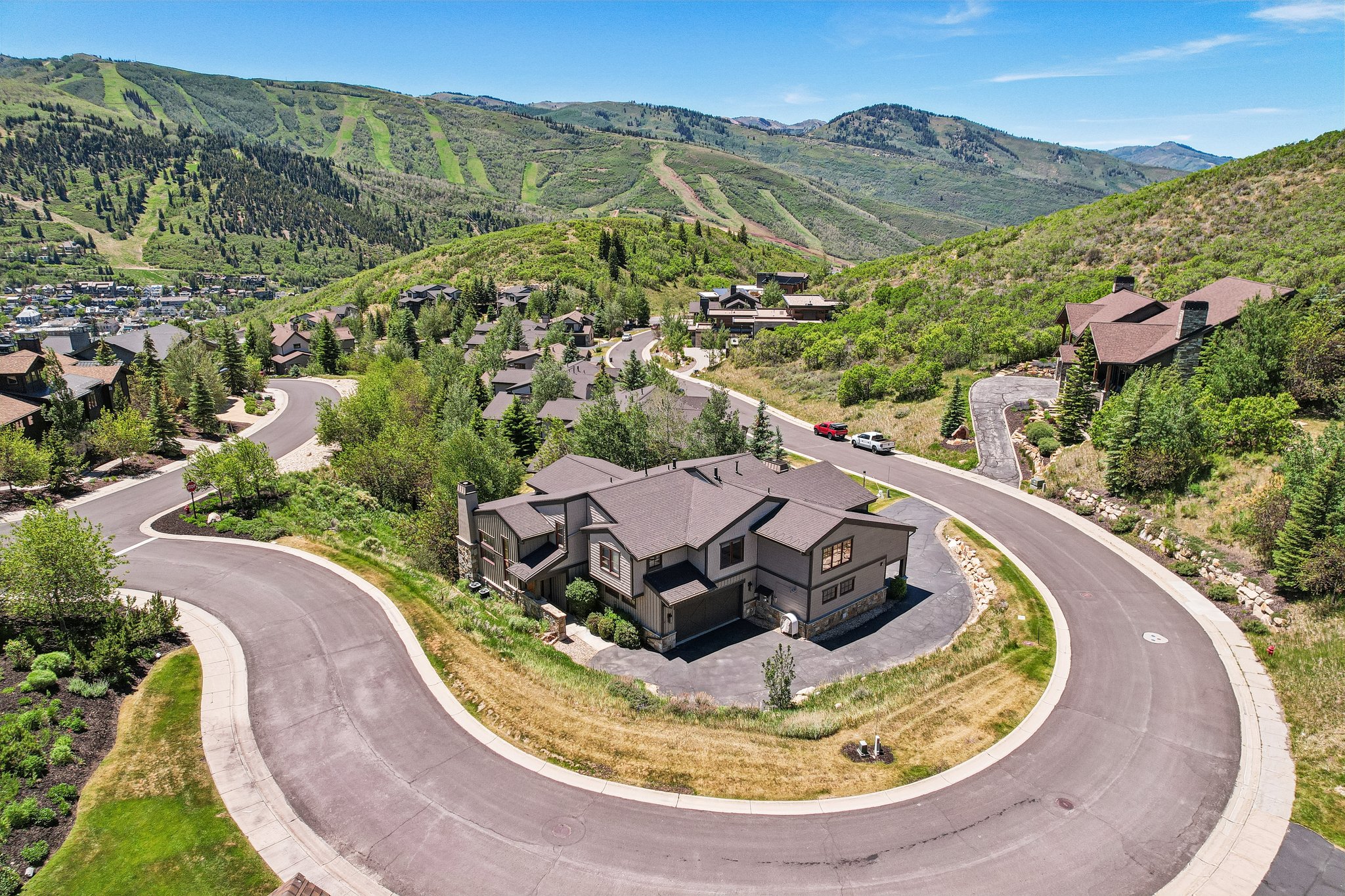 Modern residential structure with a multi-gabled roof, stone accents, and an attached garage