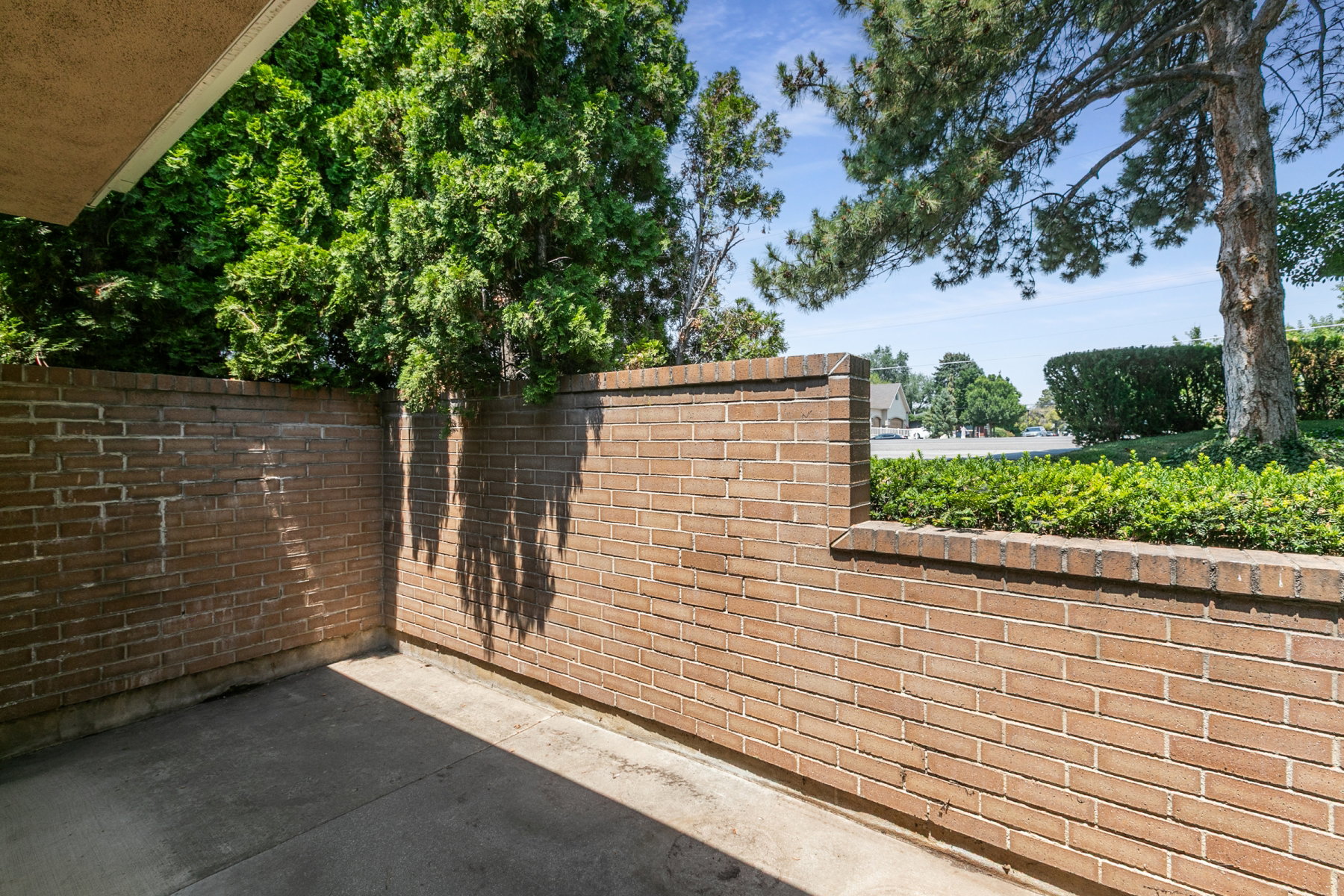 Private patio area featuring a concrete surface and substantial brick walls