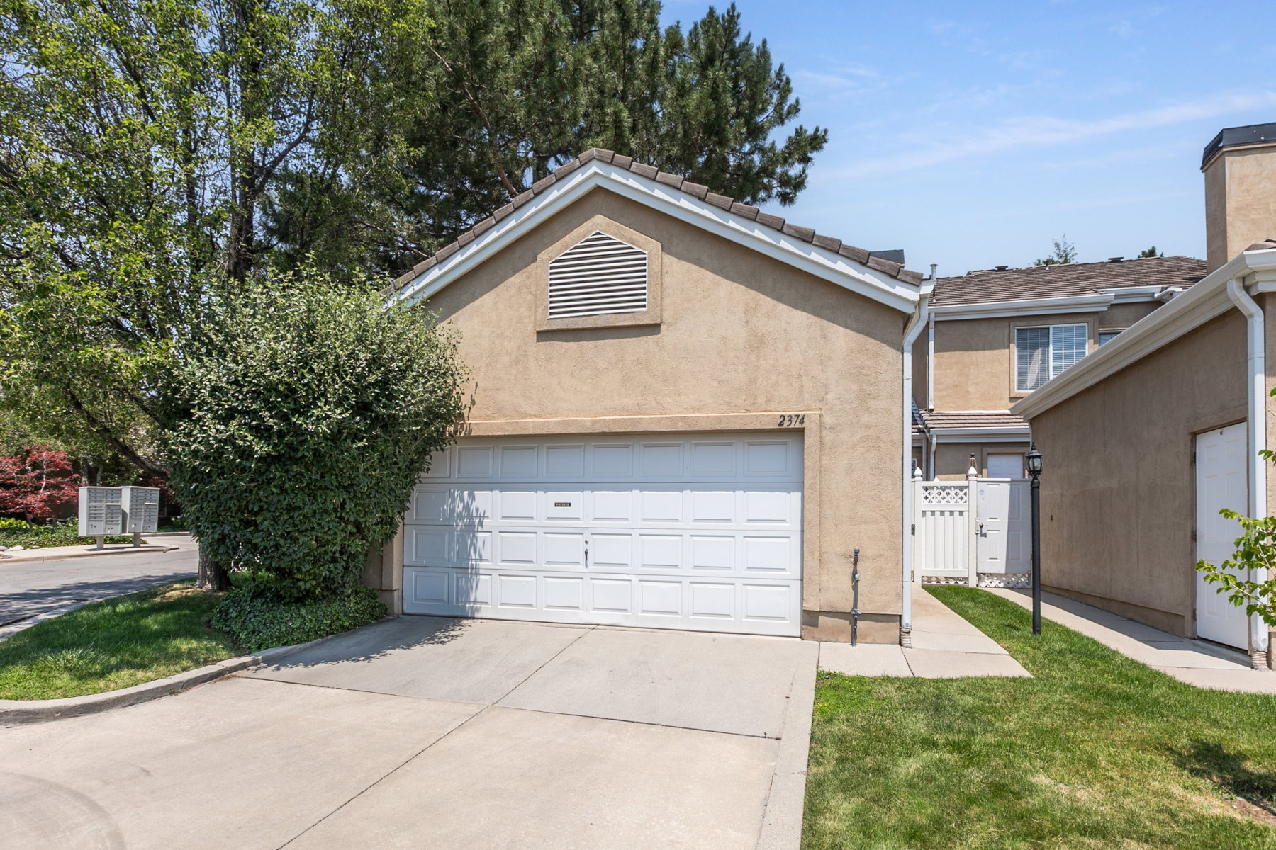Stucco exterior featuring a two-car garage with a panel door