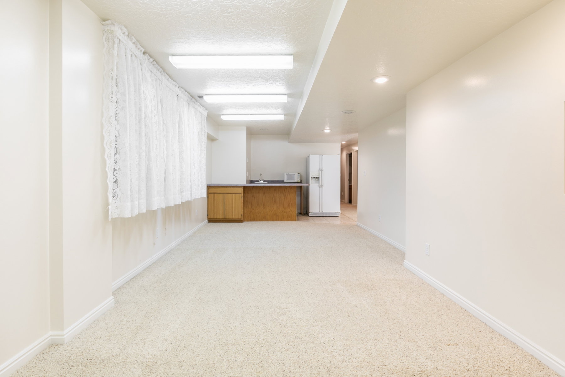 Spacious room with light-toned carpeting and recessed lighting