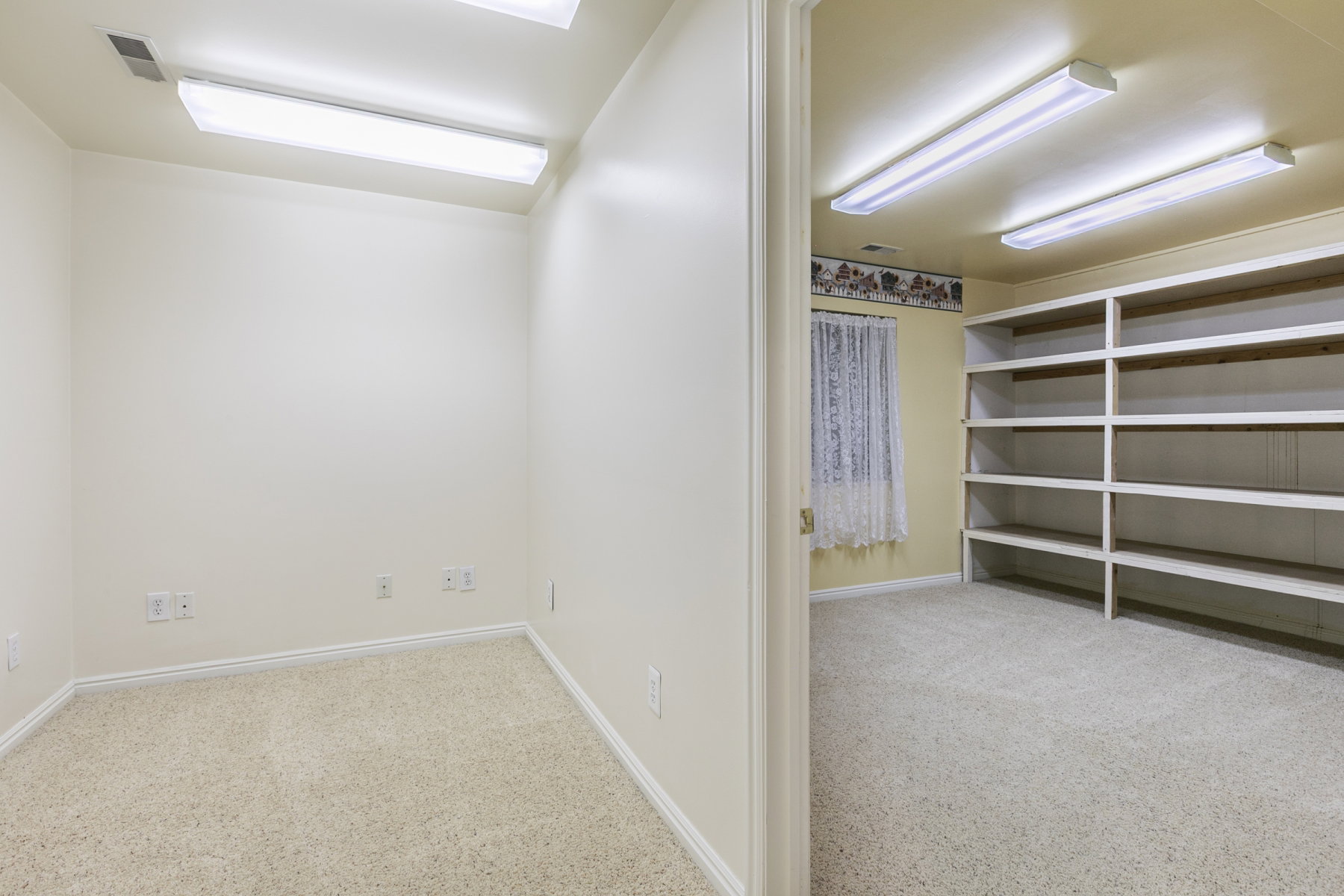 Two distinct rooms, each with neutral carpet flooring and overhead fluorescent lighting