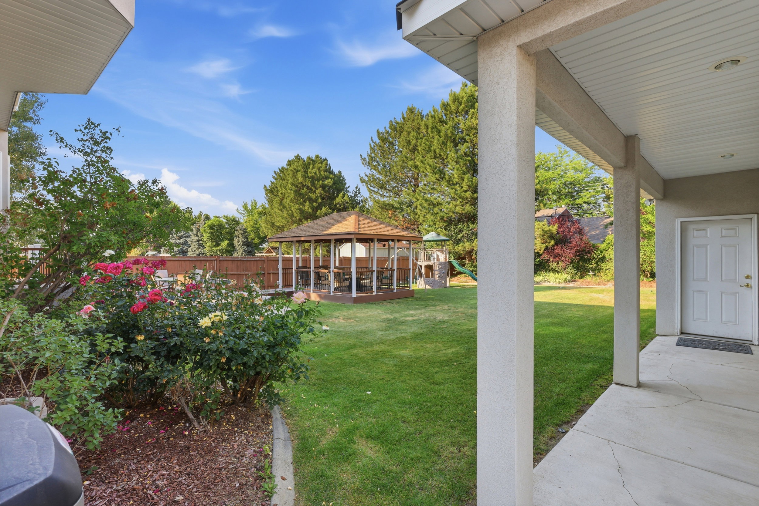 Expansive green lawn with a wooden gazebo on a raised deck
