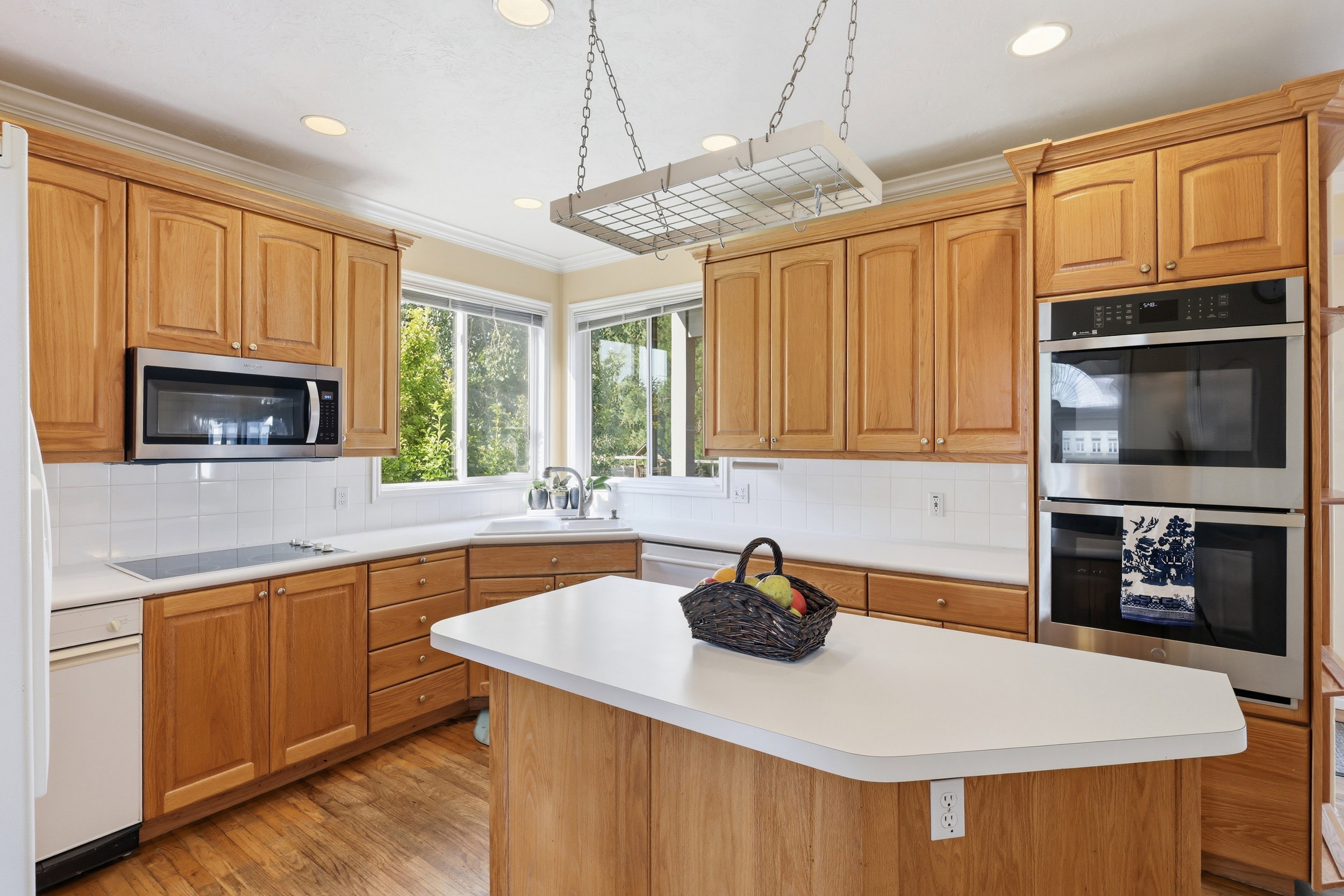 Kitchen featuring wood-finish cabinetry, white countertops, and a white tile backsplash