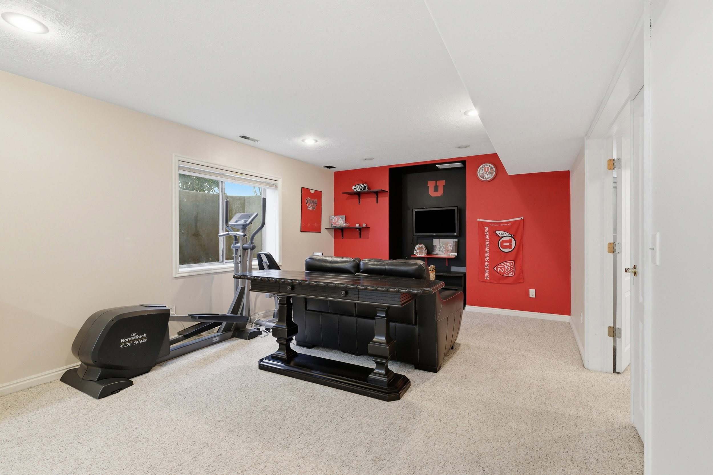 Recessed lighting illuminates this versatile room with plush carpeting