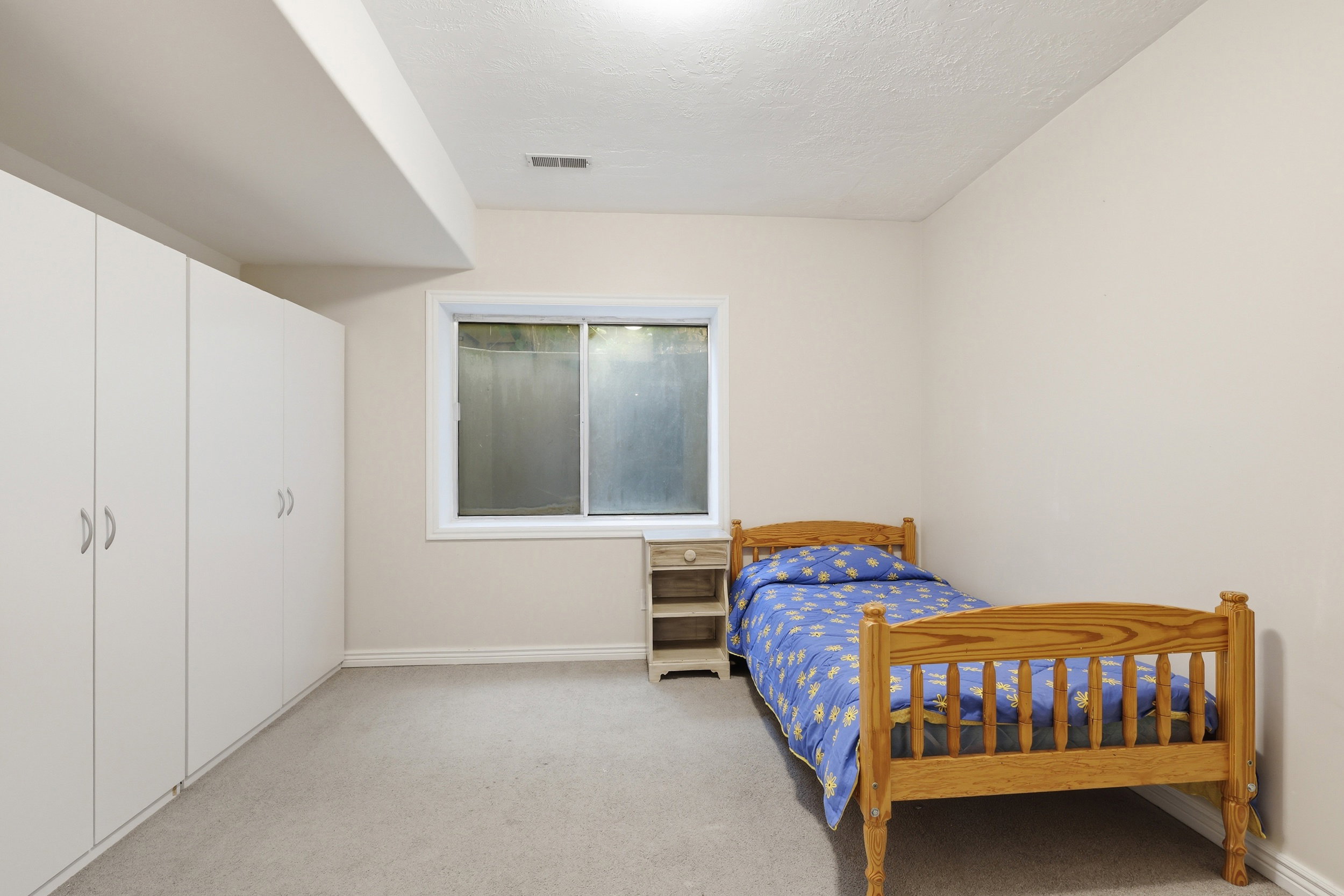 Room featuring light beige walls, neutral carpet flooring, and a single window