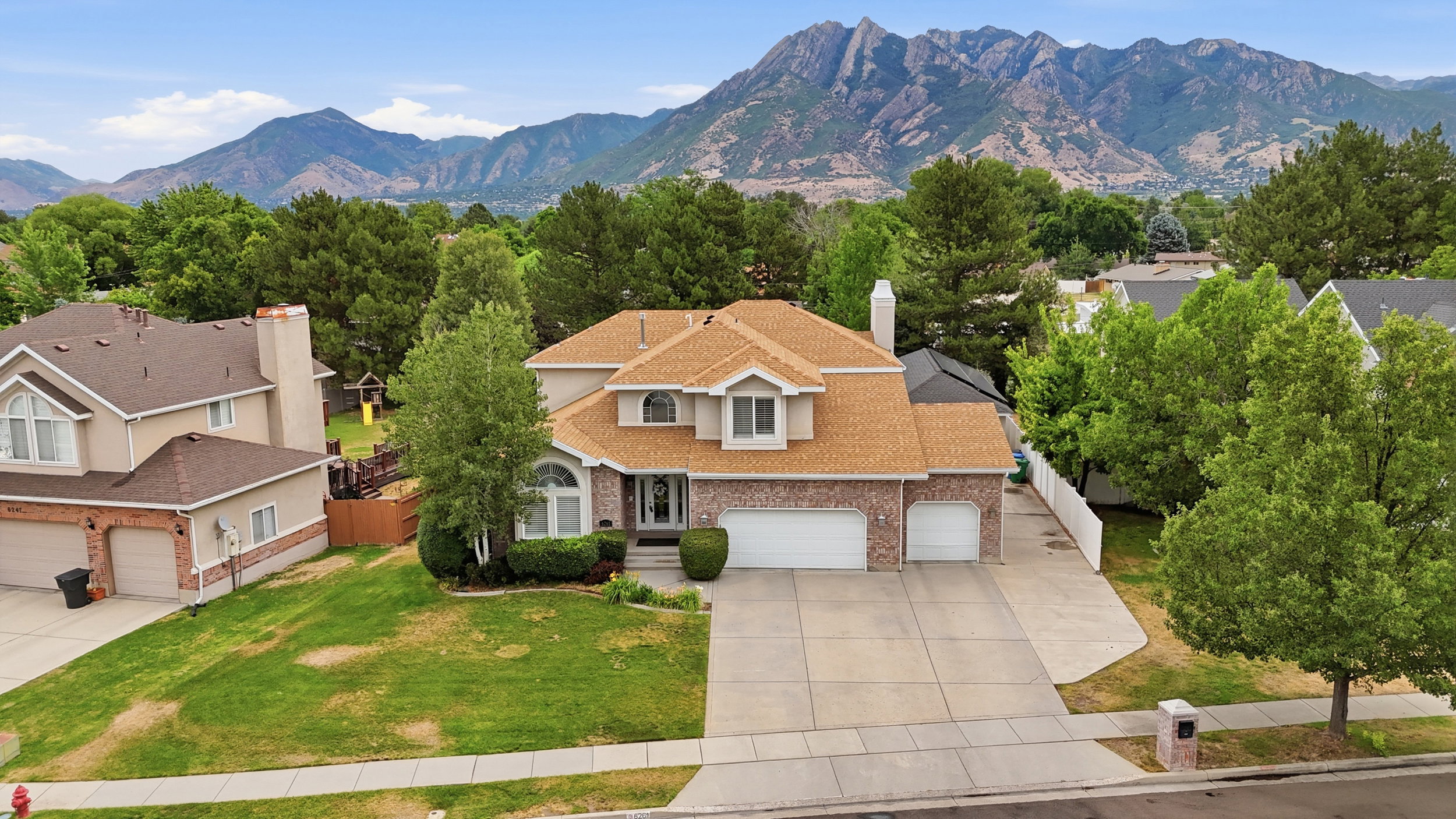 Traditional-style residence featuring a brick and stucco facade, a two-car garage, and an arched entry with sidelights