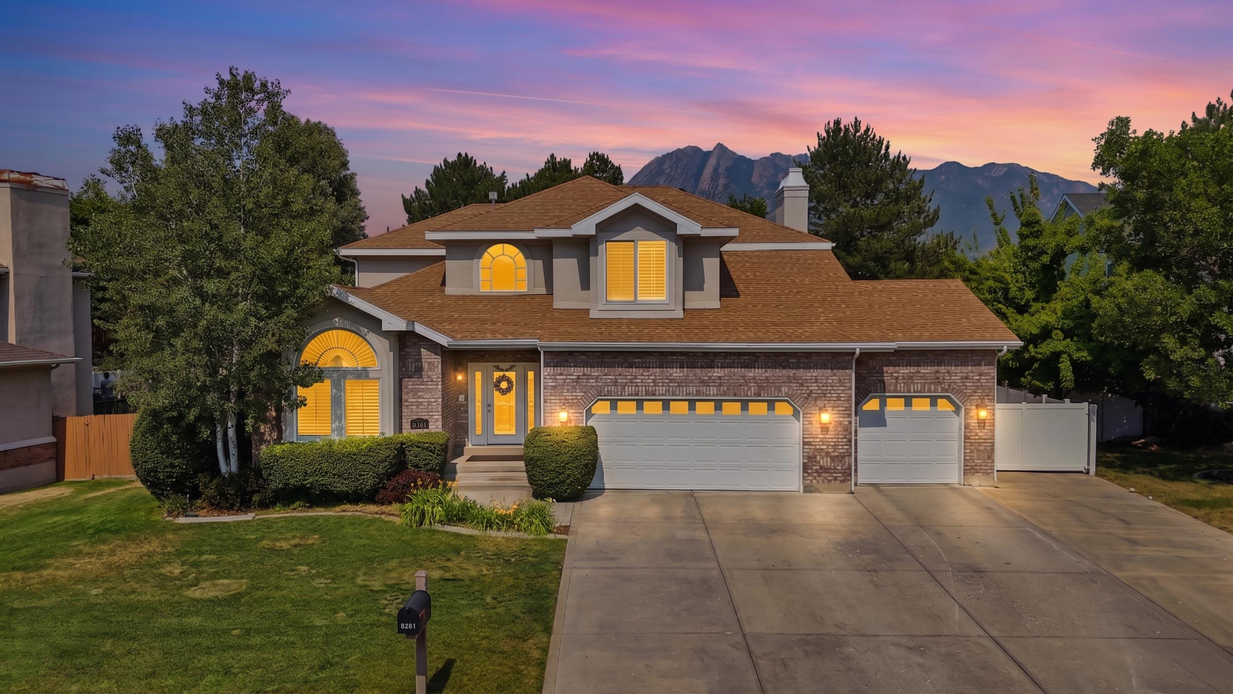 Brick and stucco exterior with a brown shingle roof