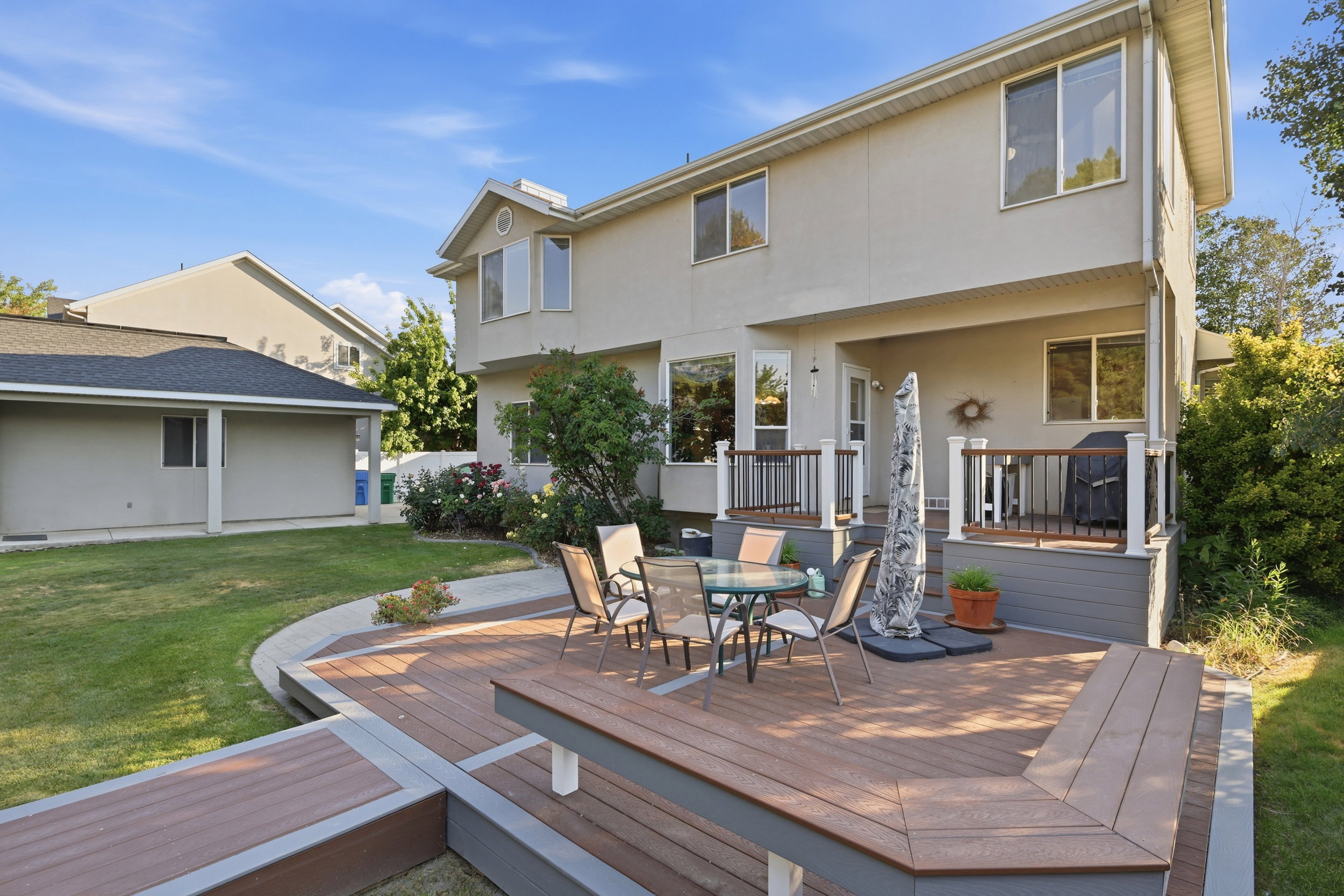 Multi-level composite deck featuring built-in bench seating and a covered patio area