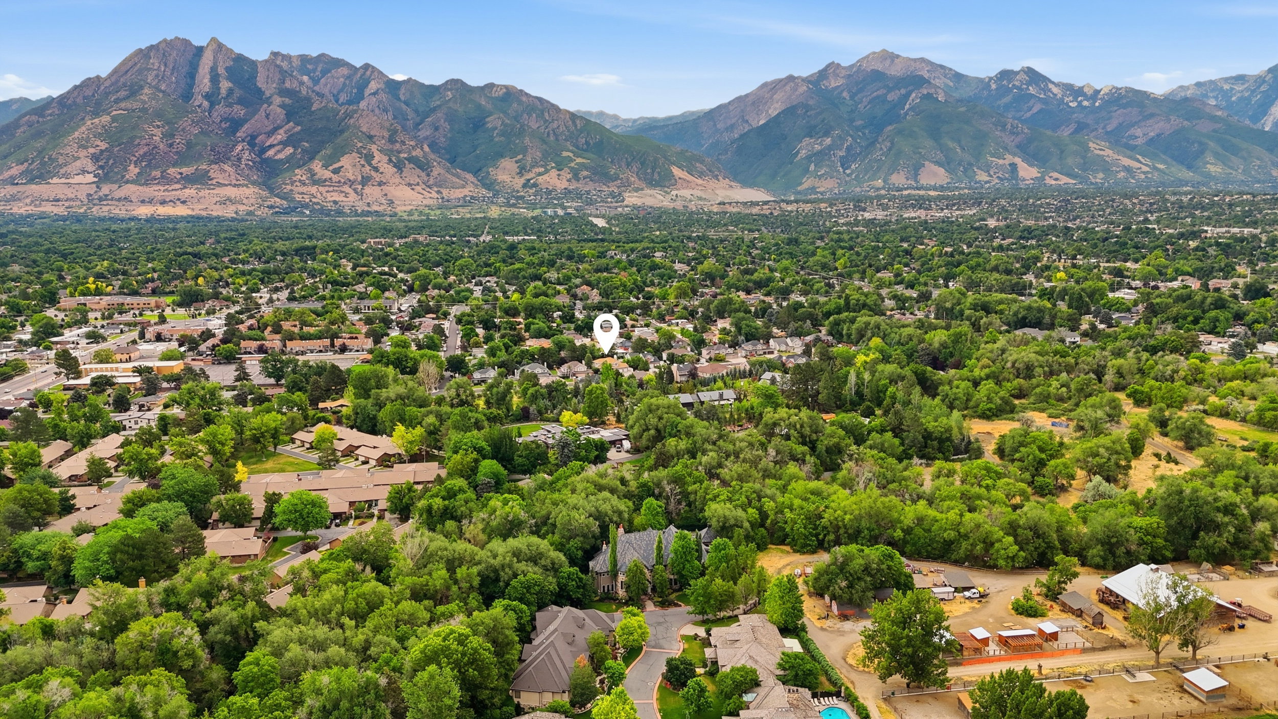 Mountain landscape framing a verdant residential area featuring extensive tree coverage