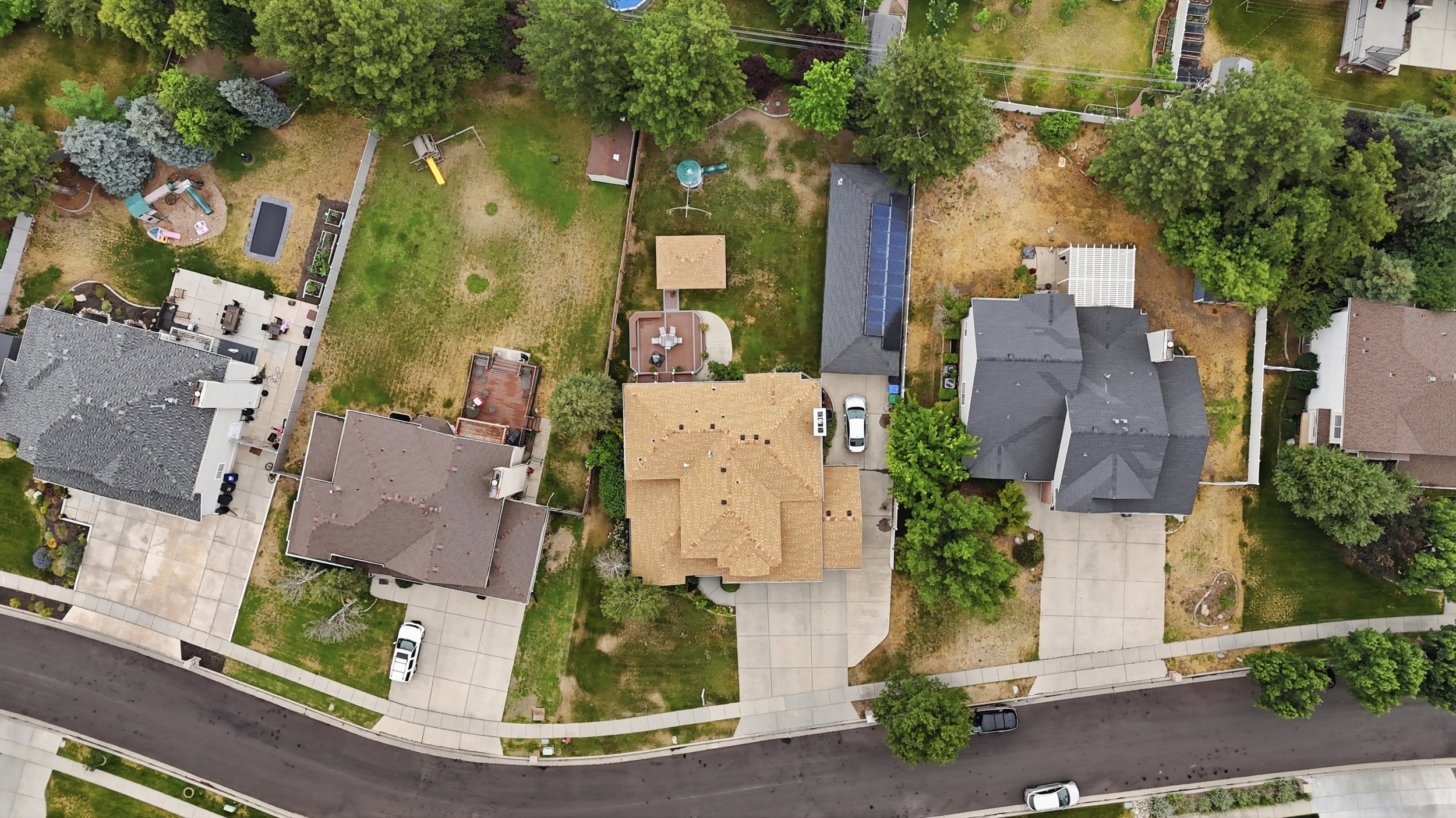 Property features a large private lot with mature trees, a multi-car driveway, and a spacious backyard