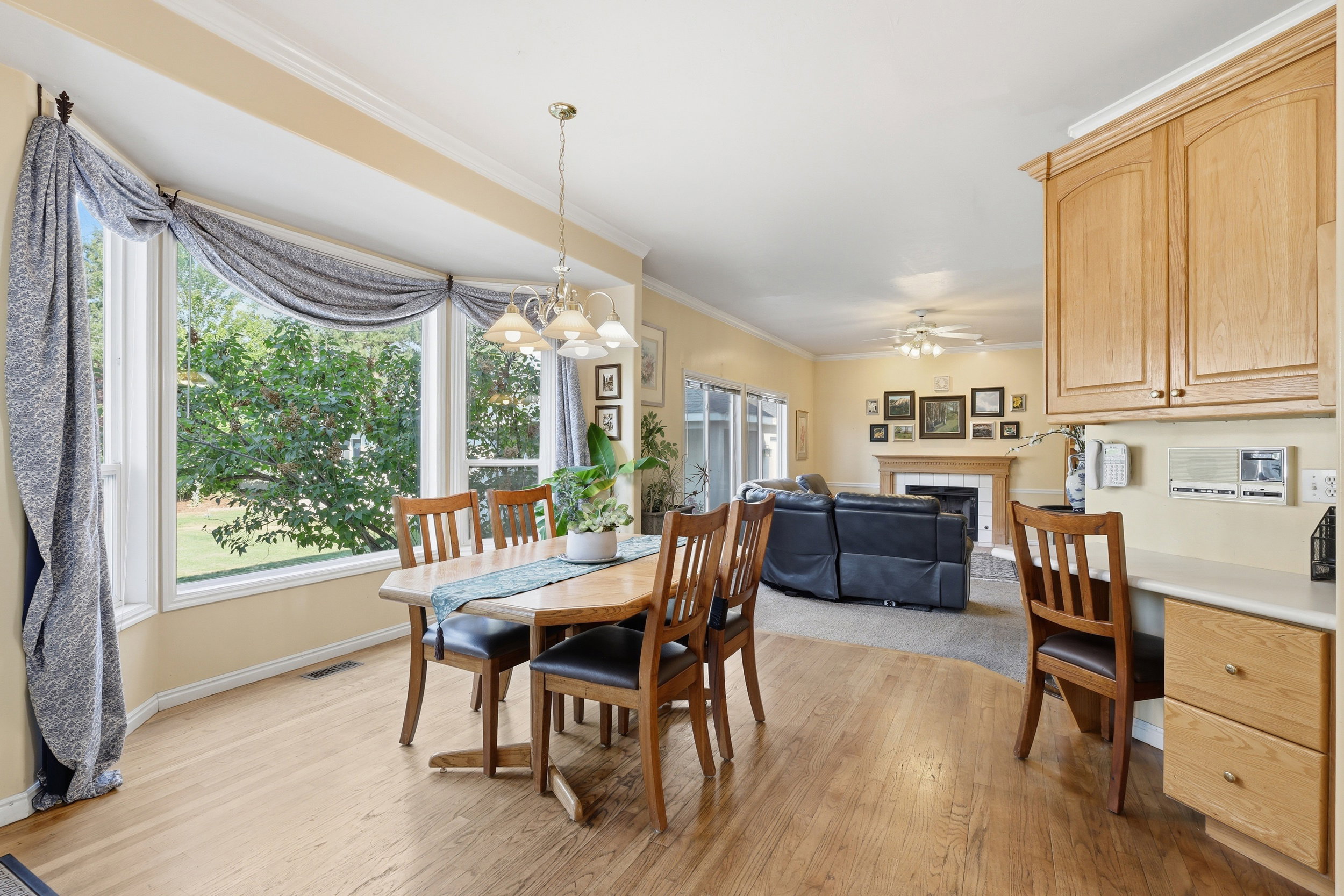 Hardwood-style flooring extends through this open-concept dining area featuring a bay window
