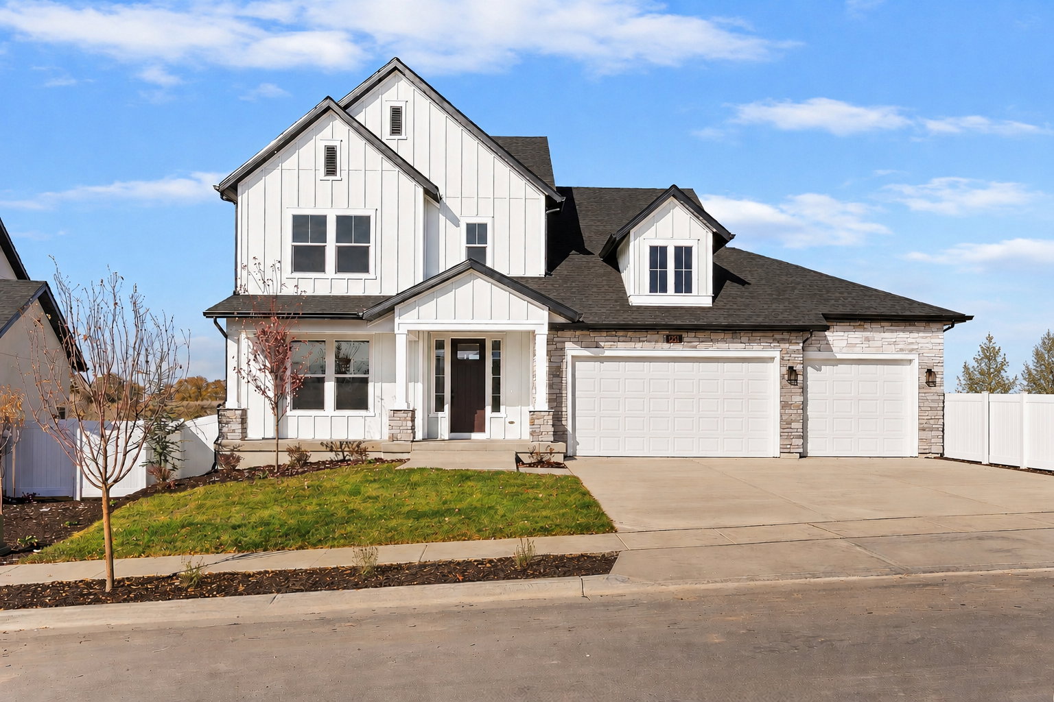 Modern farmhouse architecture featuring white vertical siding and dark shingle roofing