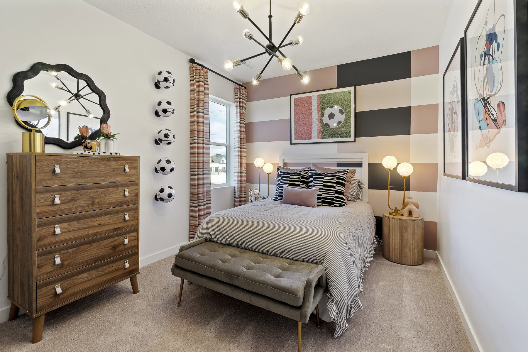 Carpeted room featuring a window with patterned curtains, a contemporary chandelier, and a decorative accent wall with horizontal blocks