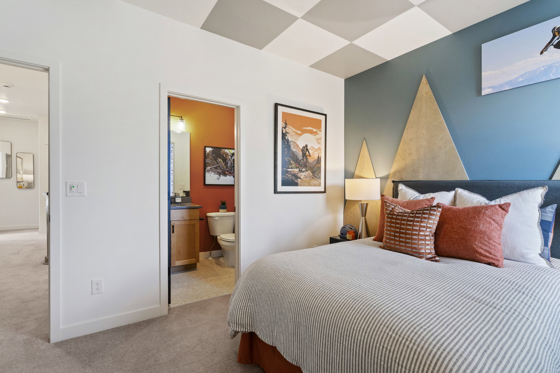 Bedroom featuring wall-mounted geometric accents and a checkerboard ceiling design