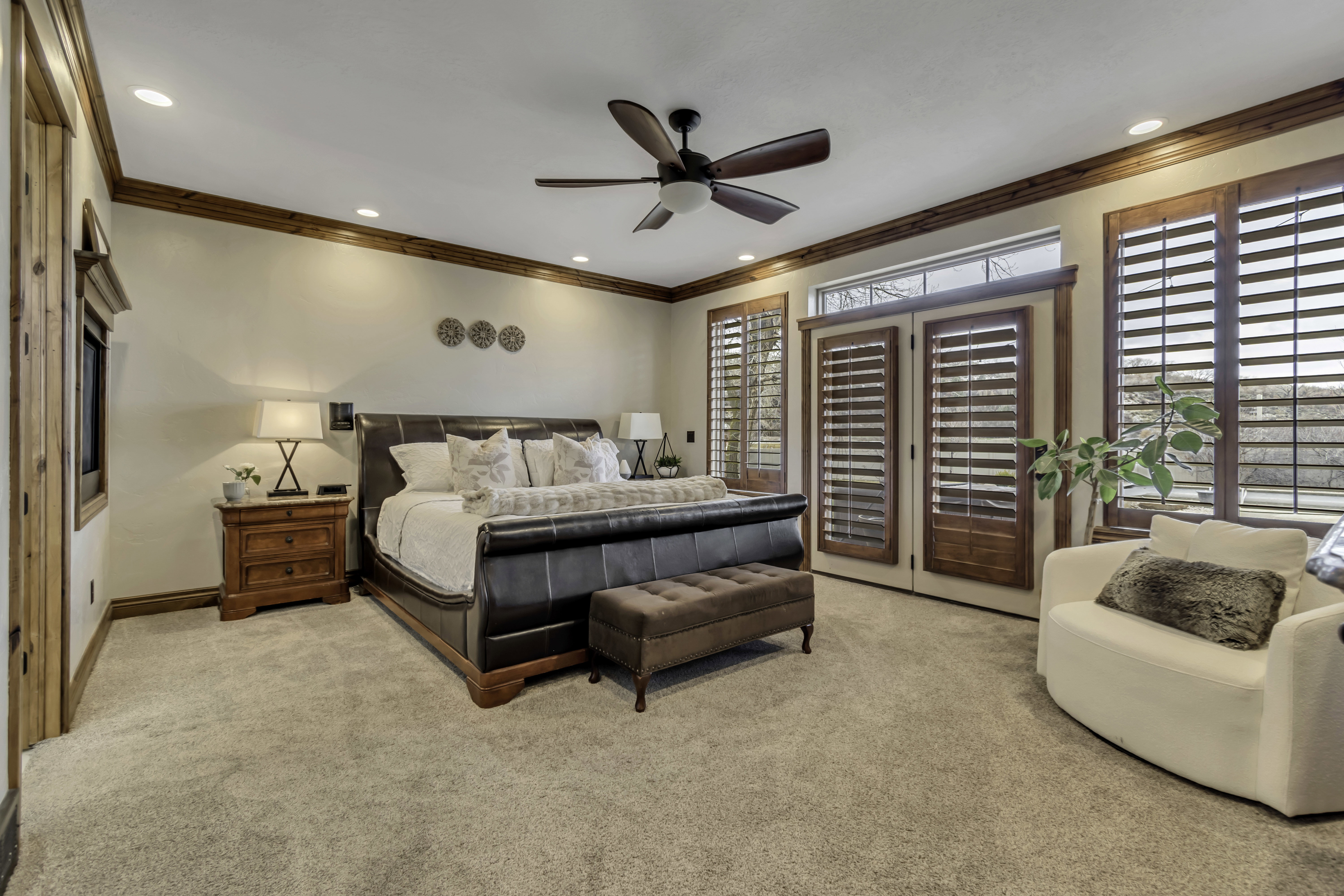 Carpeted room featuring wood-trim accents and a ceiling fan