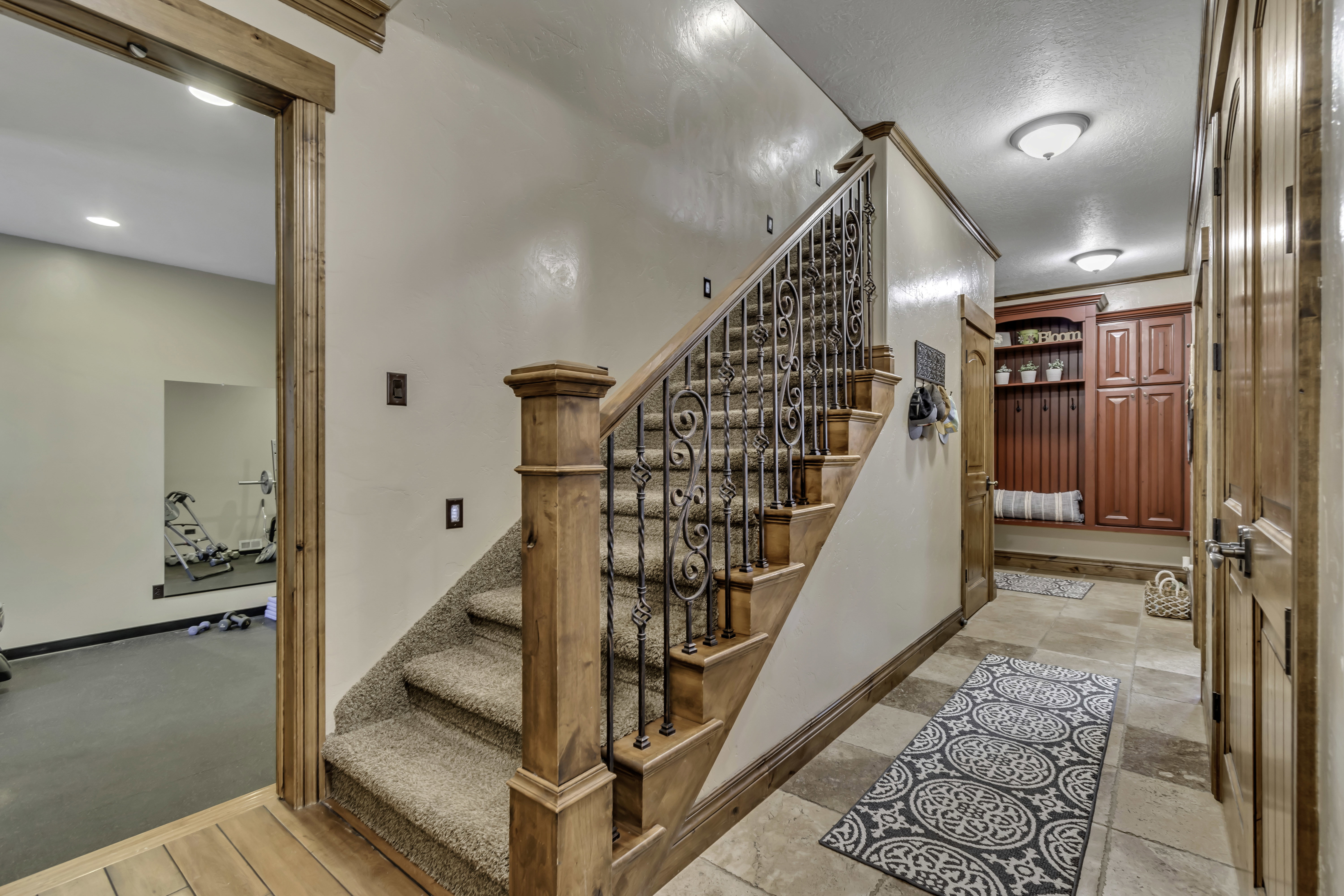 Carpeted staircase with ornate wrought iron balusters and wood newel posts