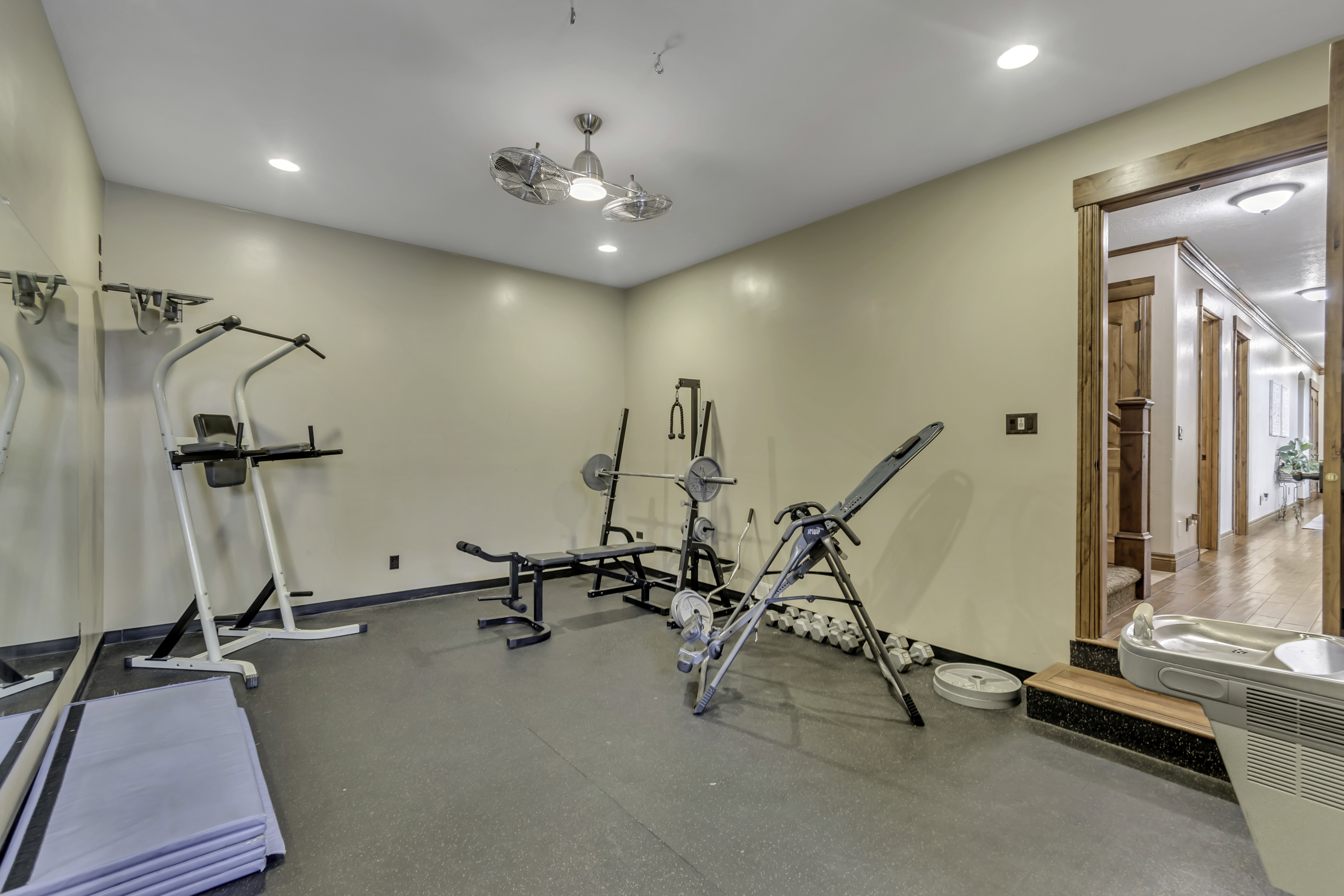 Dedicated fitness room featuring rubber flooring, a mirrored wall, recessed lighting, and a multi-speed ceiling fan