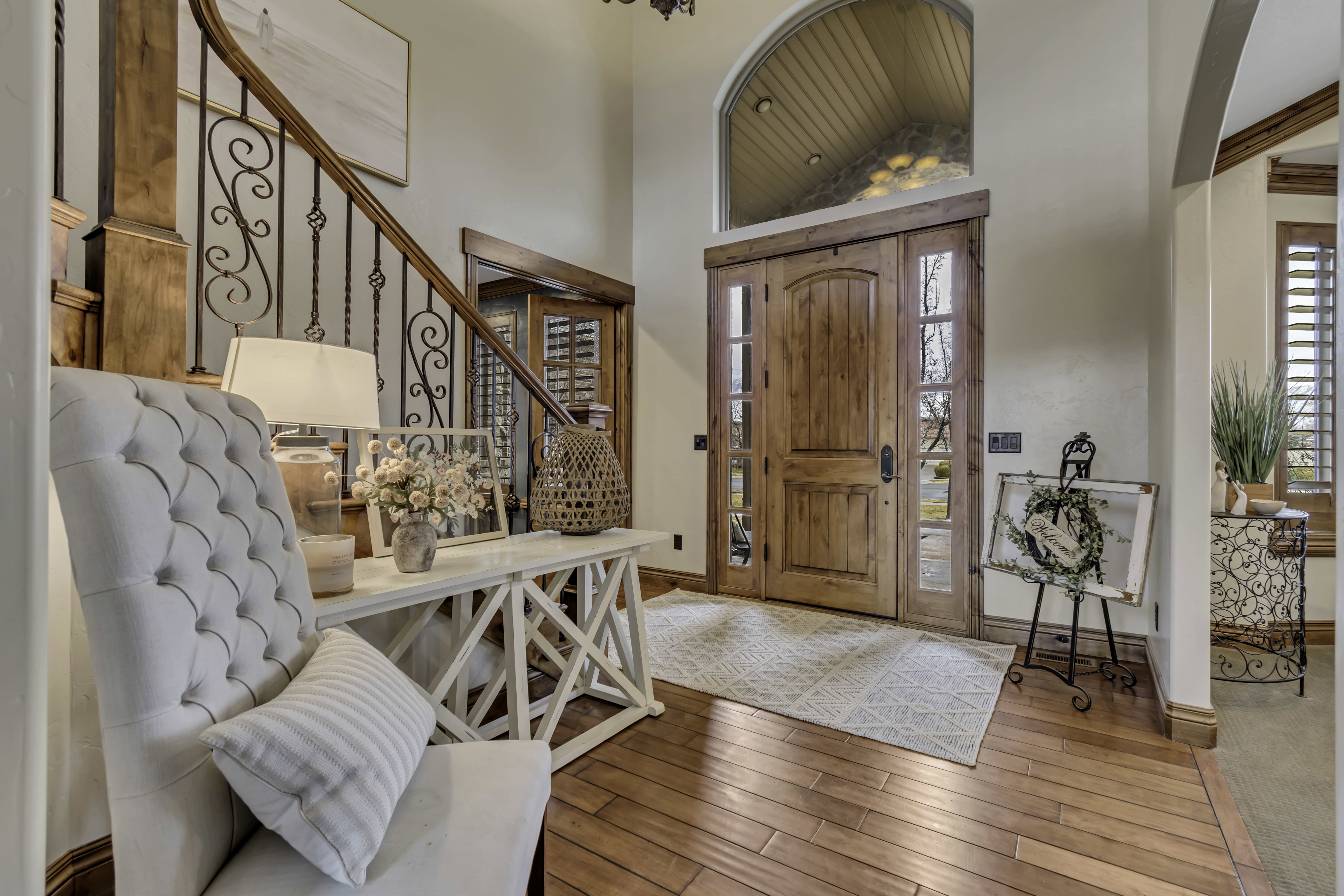 Grand entry featuring a solid wood front door with sidelights and an arched transom window